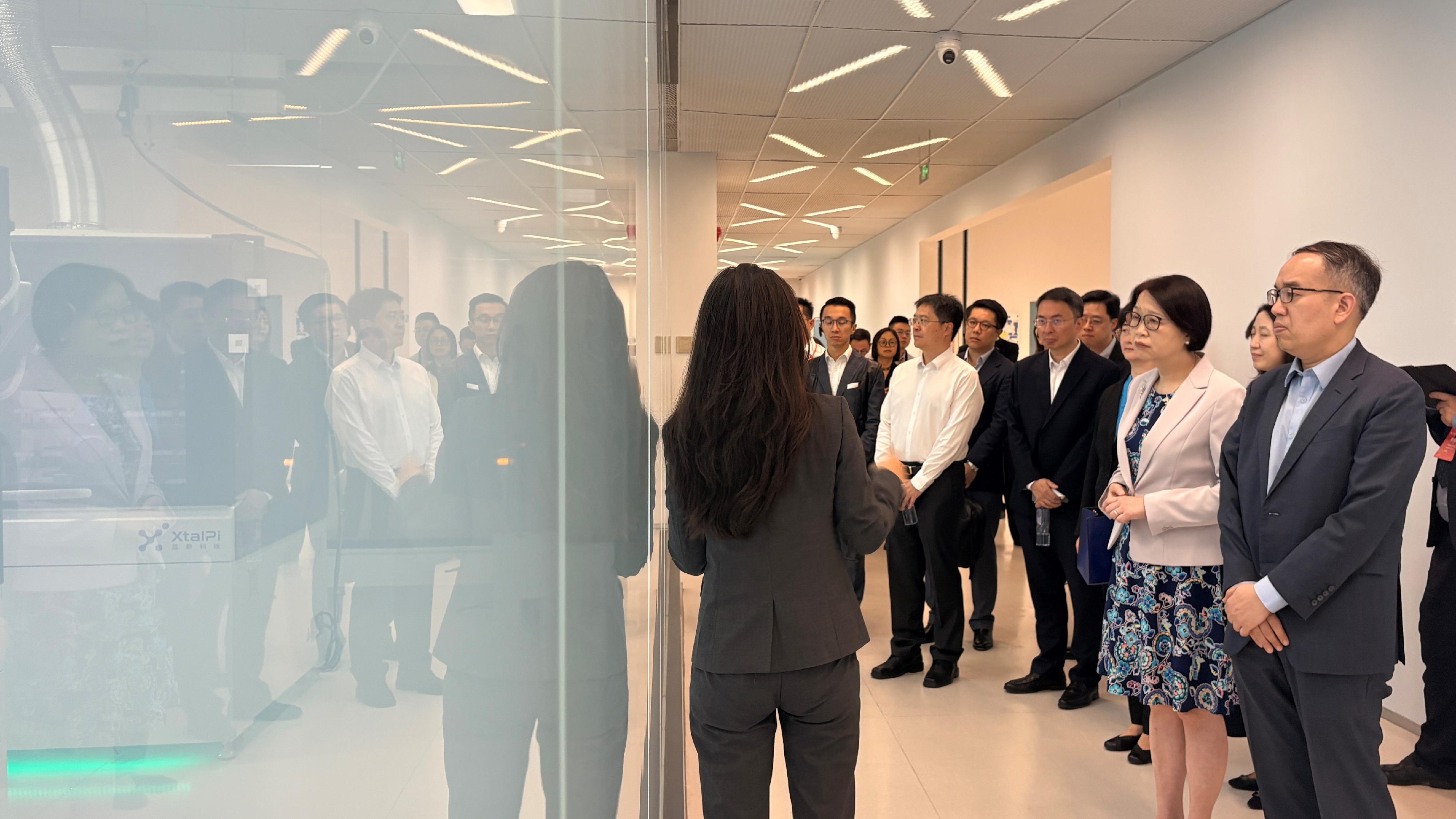 財經事務及庫務局局長許正宇今日(五月二十七日)率領代表團前往深圳,視察河套深港科技創新合作區深圳園區。圖示許正宇(前排右一)、財經事務及庫務局常任秘書長(財經事務)張馮泳萍(前排右二)及代表團成員參觀深圳企業晶泰科技,了解公司如何以人工智能和機器人技術驅動多行業發展。