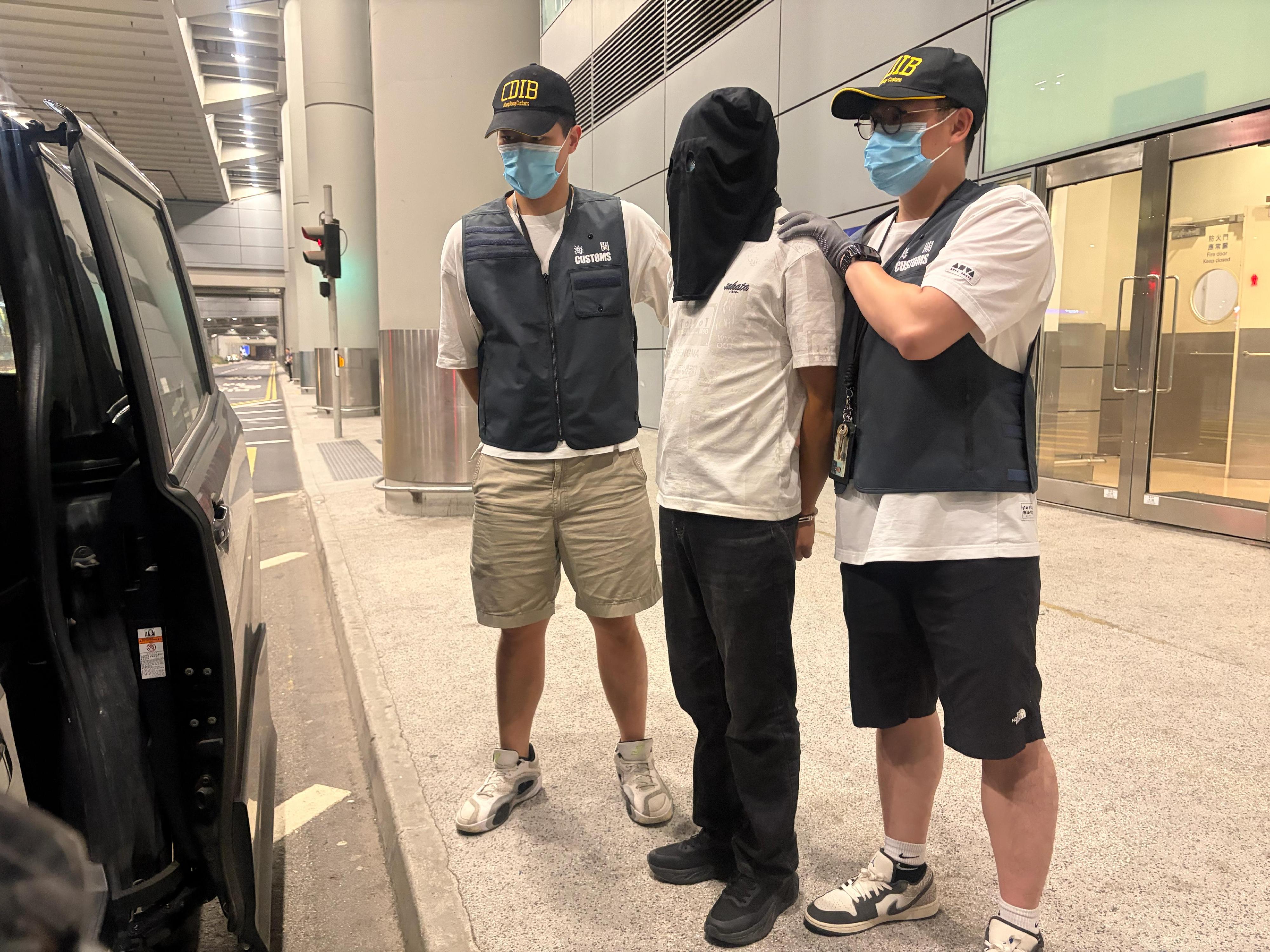 香港海關今日(五月二十七日)在香港國際機場偵破一宗行李藏毒的販毒案件,檢獲約六千三百克懷疑大麻花,市值約一百一十萬元。圖示涉案的被捕男子(中)。