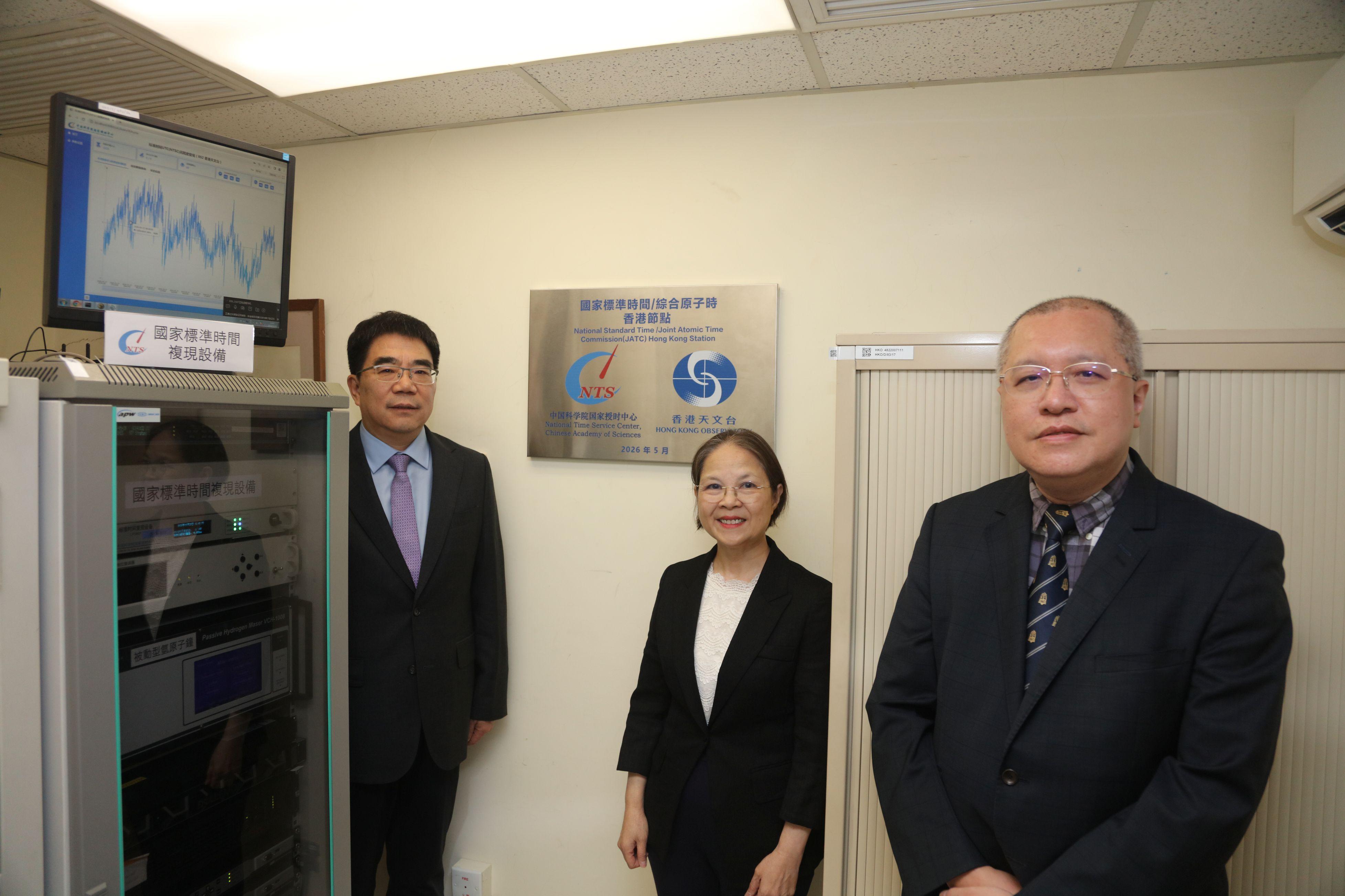 香港天文台與國家授時中心「國家標準時間及國家綜合原子時香港節點」今日（五月二十八日）舉行揭牌儀式。圖示環境及生態局副局長黃淑嫻（中）、國家授時中心主任張首剛博士（左）和香港天文台台長陳栢緯博士（右）今日（五月二十八日）在設置於香港天文台的國家授時中心被動型氫原子鐘和標準時間傳輸設備及首個「國家標準時間及綜合原子時香港節點」的牌匾前合照。