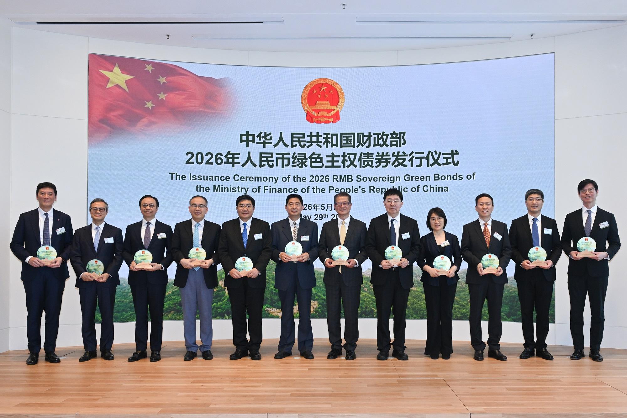 財政司司長陳茂波今日(五月二十九日)出席中華人民共和國財政部2026年人民幣綠色主權債券發行儀式。圖示陳茂波(右六)、中華人民共和國財政部副部長宋其超(左六)、中華人民共和國財政部債務管理司司長李大偉(右五)、中國銀行副行長楊軍(右三)、交通銀行副行長顧斌(右二)、滙豐亞洲及中東地區聯席行政總裁廖宜建(右一)和其他嘉賓在活動主持儀式。