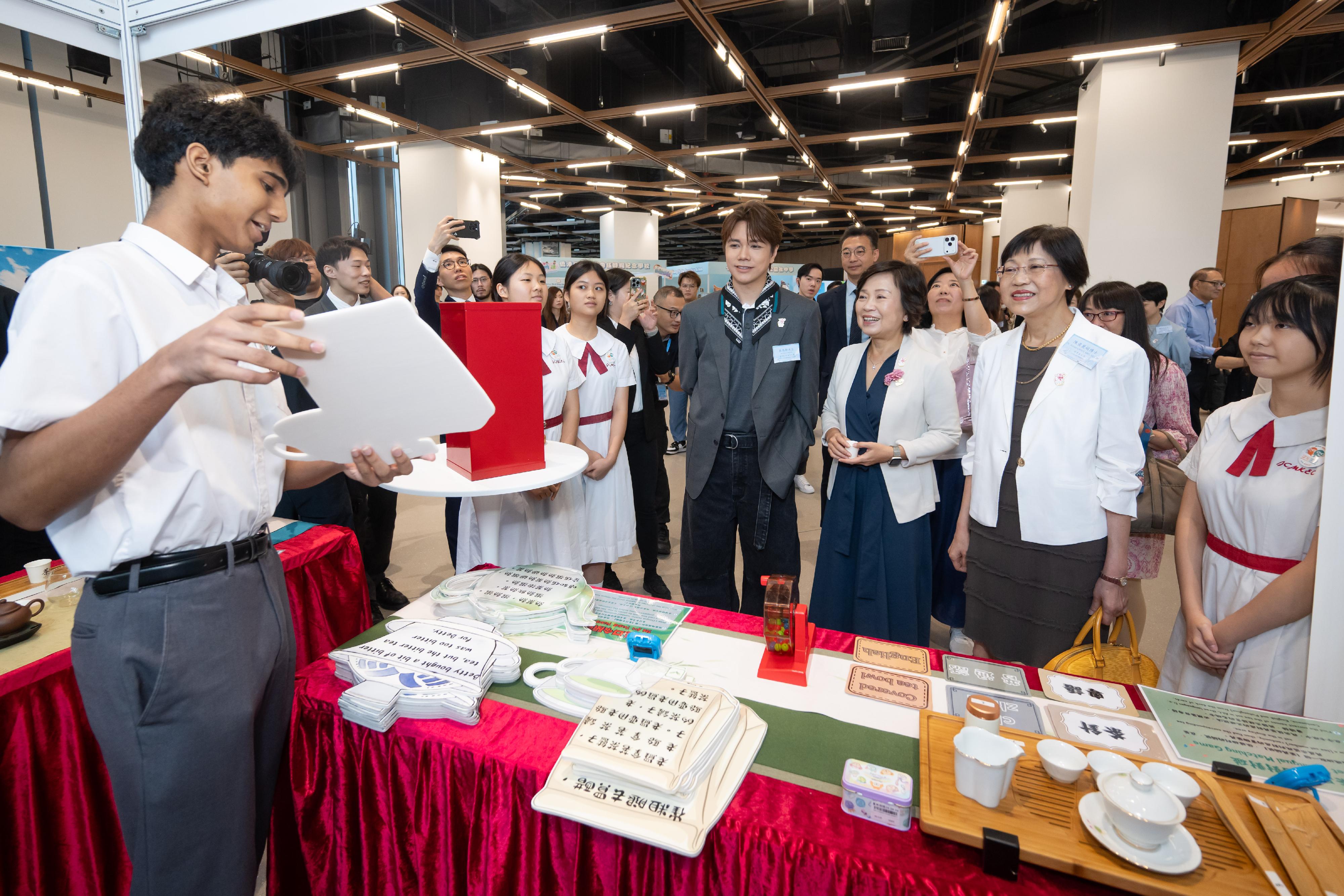 教育局和語文教育及研究常務委員會(語常會)今日(五月三十日)舉行「學生語文大使計劃——自主學習語文展覽」。圖示教育局局長蔡若蓮博士(右三)與語常會主席陳黃麗娟博士(右二)和語常會三十周年大使張敬軒(右四)在展覽攤位與學生語文大使互動。