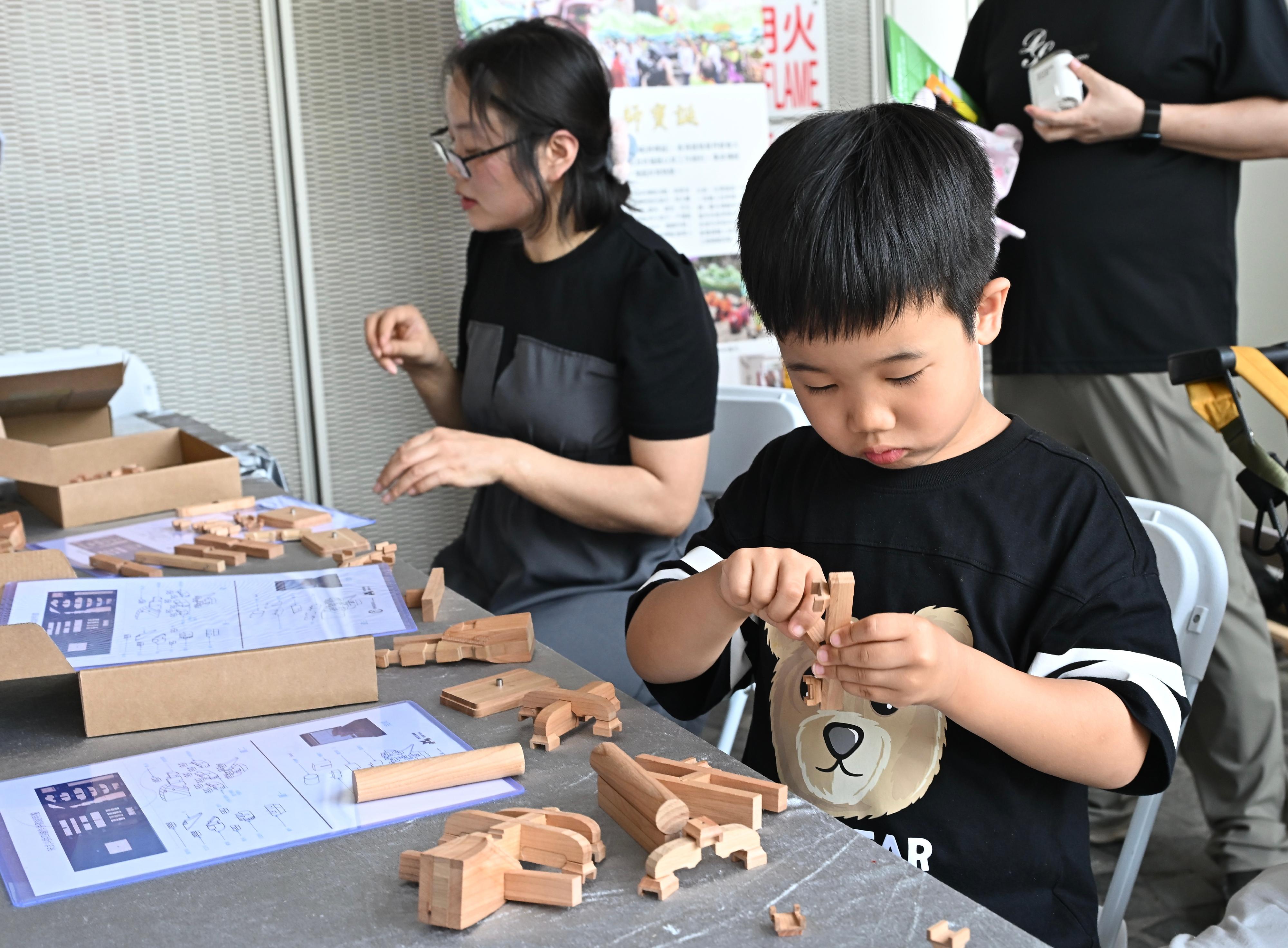 香港賽馬會呈獻系列︰「香港非遺月2026」非遺嘉年華今明兩日（五月三十日和三十一日）舉行。圖示市民體驗傳統鄉村建築修繕技藝&mdash;榫卯。

