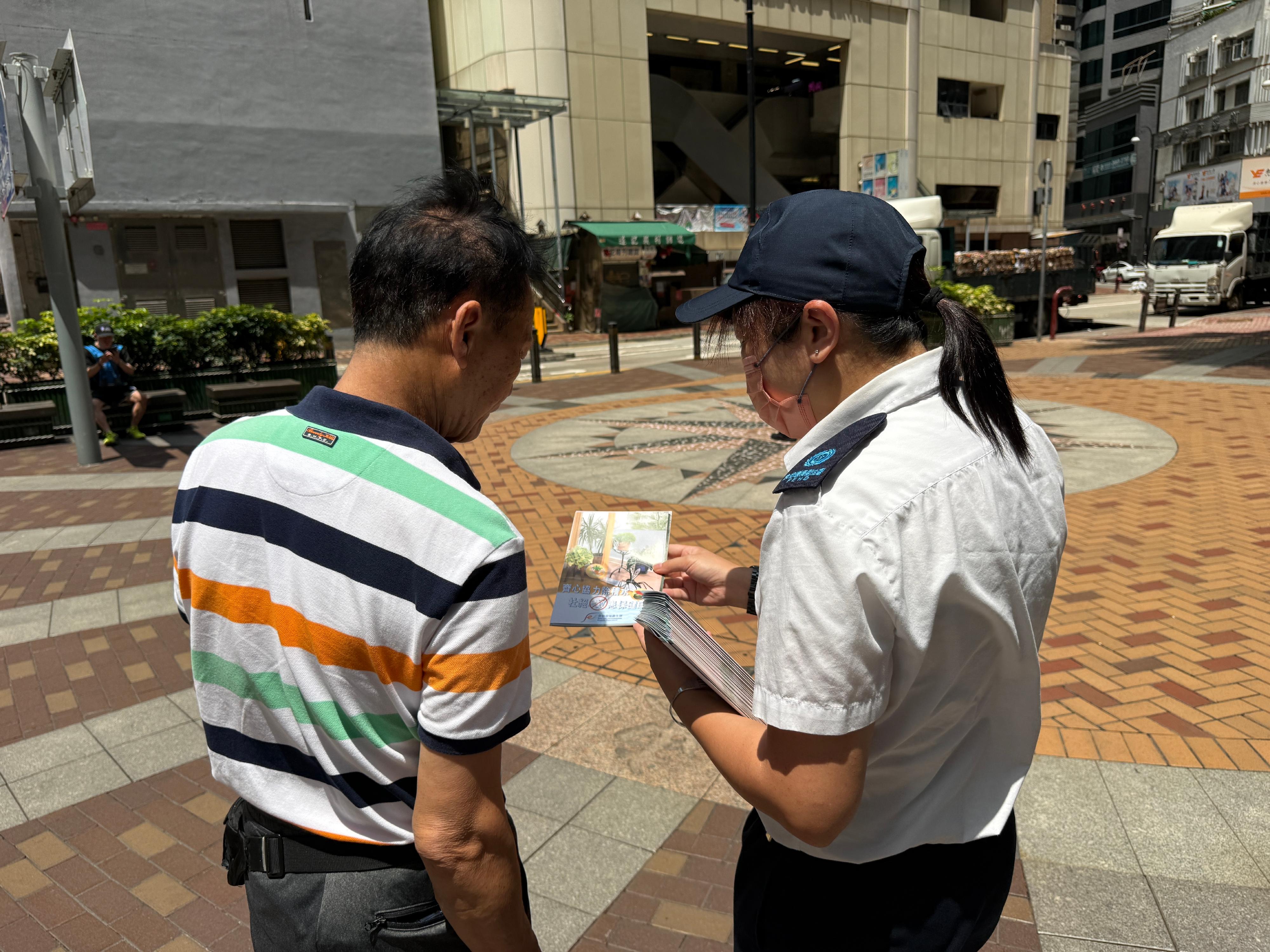 The Food and Environmental Hygiene Department (FEHD) today (June 1) released the sixth batch of gravidtrap indexes and density indexes for Aedes albopictus in May, covering 19 survey areas. Photo shows an FEHD staff member distributing promotional leaflets to members of the public in the vicinity of Sheung Wan, Central and Western District, to raise public awareness on mosquito prevention and control.