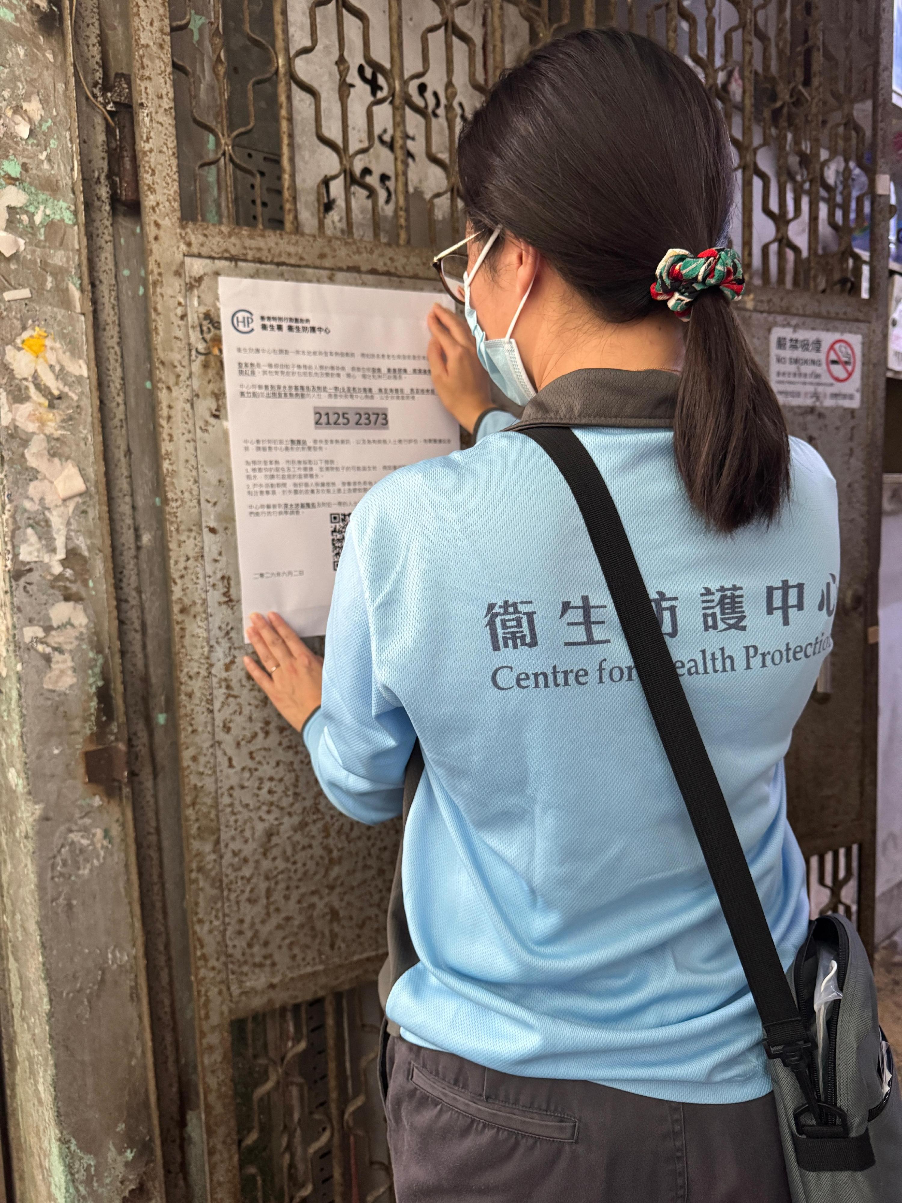 衞生署衞生防護中心(中心)今日(六月二日)跟進一宗本地登革熱個案,並正聯同政府多個部門採取適當防控措施。圖示中心人員在深水埗一帶的大廈張貼健康資訊。