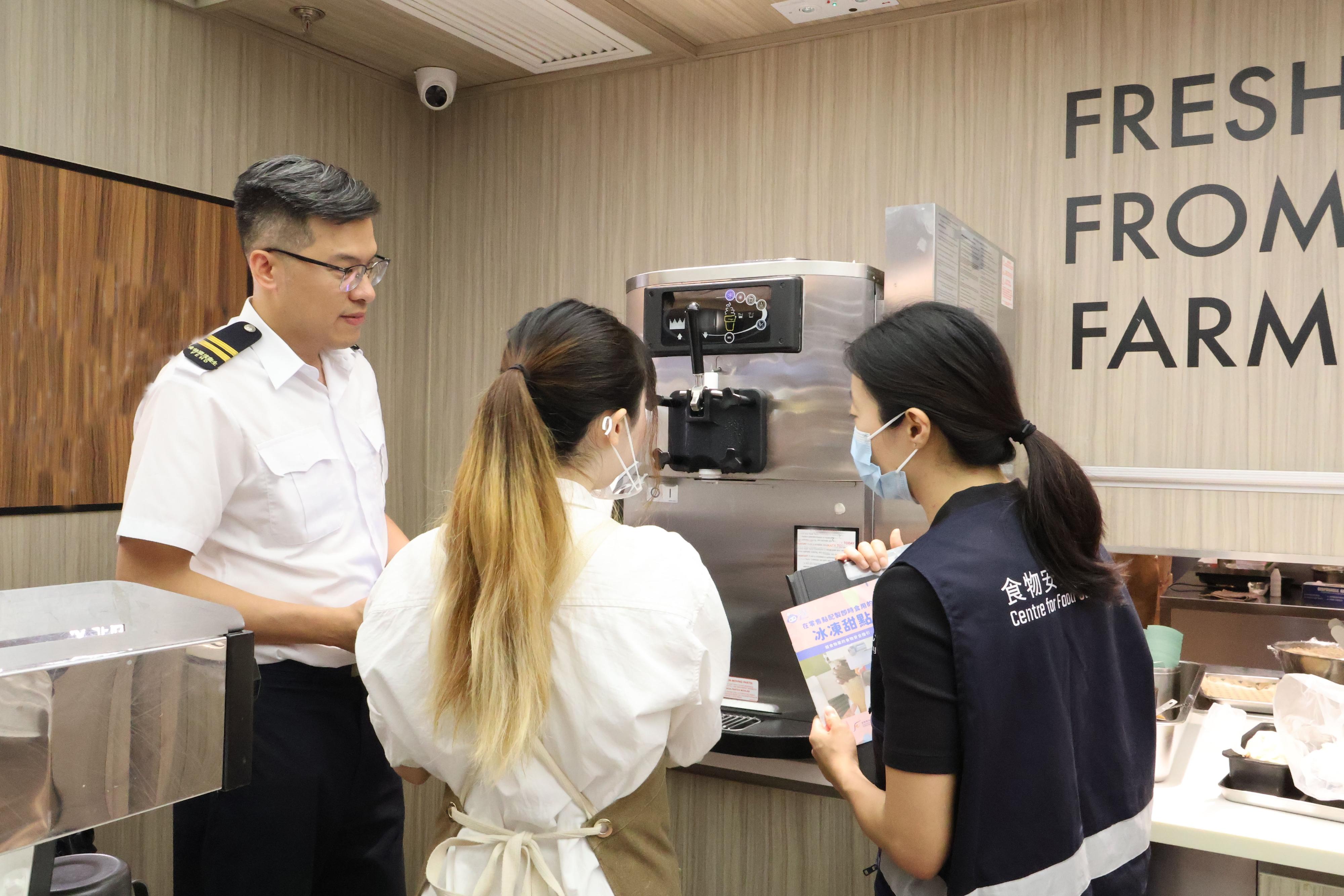 The Food and Environmental Hygiene Department (FEHD) has been stepping up inspections of licensed frozen confection outlets that manufacture frozen confections for customers' immediate consumption at the retail level across districts in Hong Kong since last week, with a view to ensuring food safety. Photo shows FEHD staff providing health education to a food handler during an inspection.
