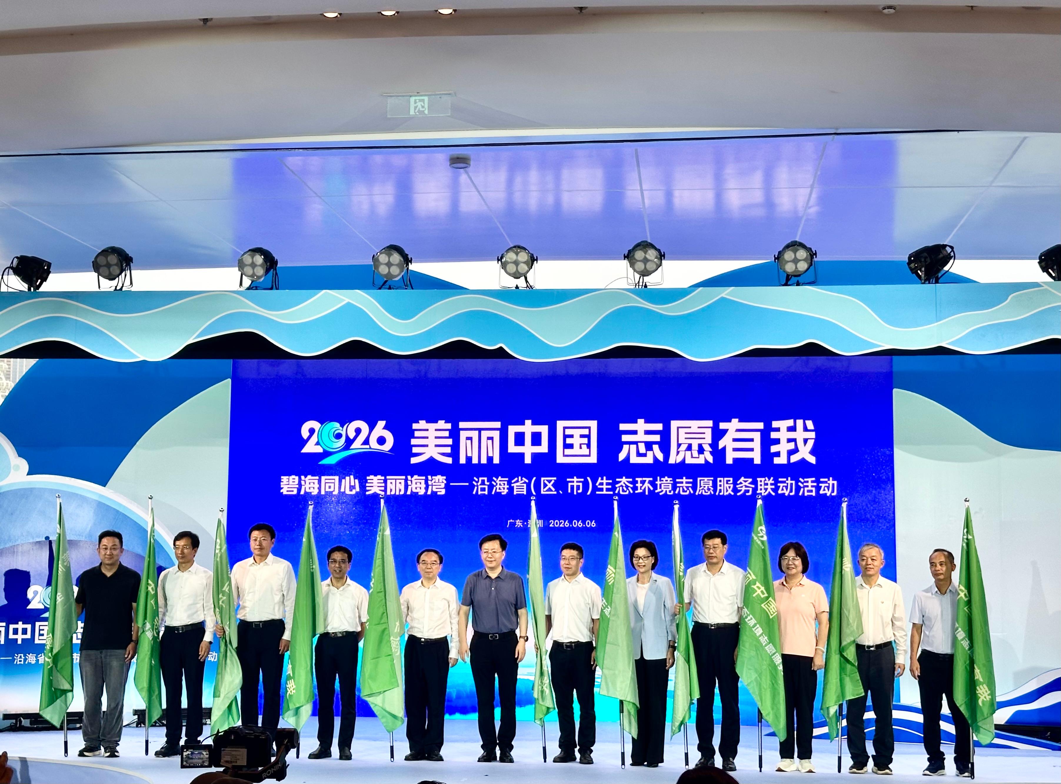 沿海省（區、市）生態環境志願服務聯動活動啓動儀式在深圳市寶安區歡樂海灣舉行。圖示國家生態環境部宣教司司長裴曉菲（左六）在啓動儀式向參與的內地生態環境部門代表授旗。
