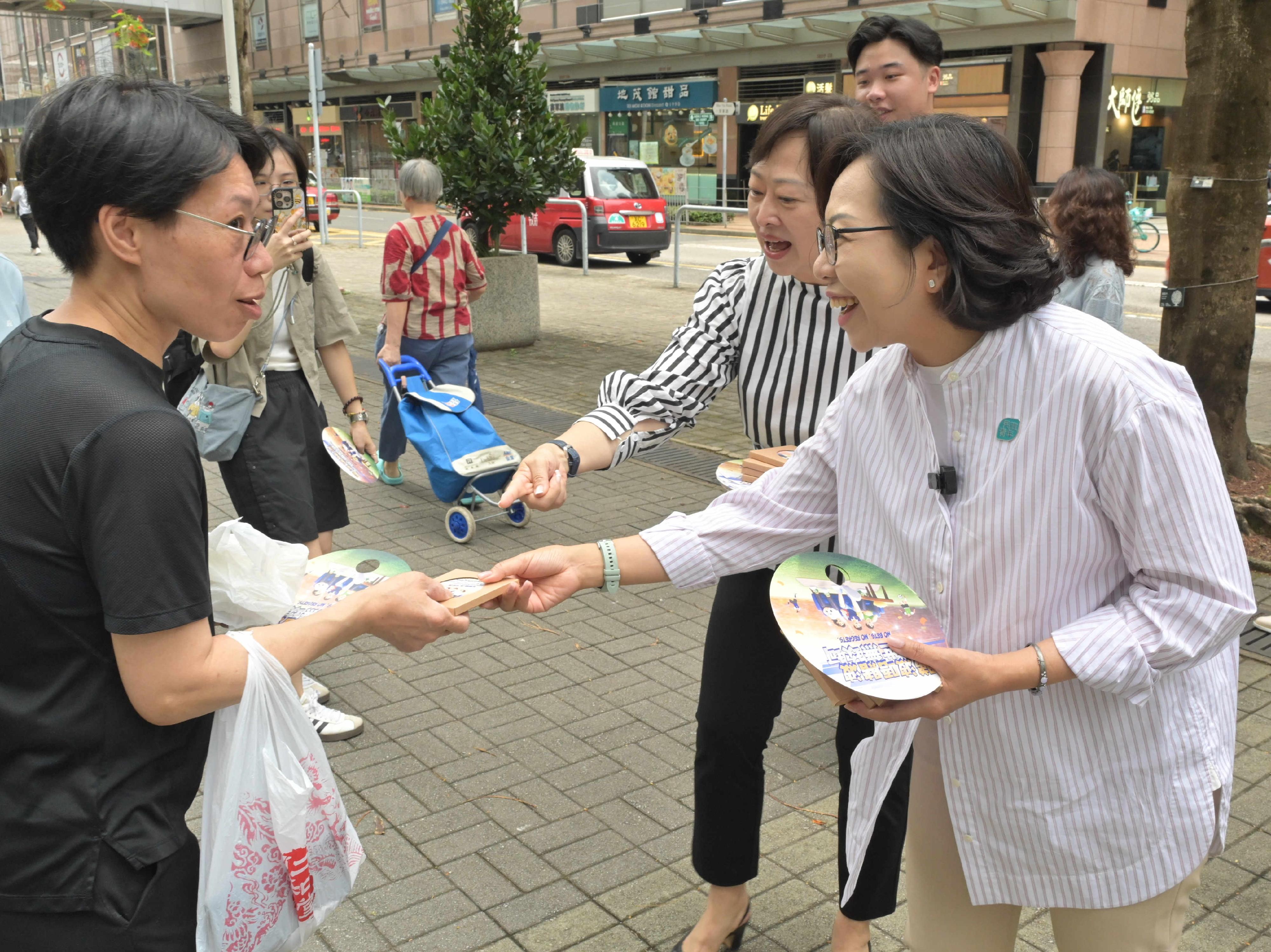 民政及青年事務局局長麥美娟(右一)及平和基金諮詢委員會主席陸海(右二)今日(六月七日)參觀流動宣傳車「抗賭平和號」,並向市民派發抗賭宣傳品。