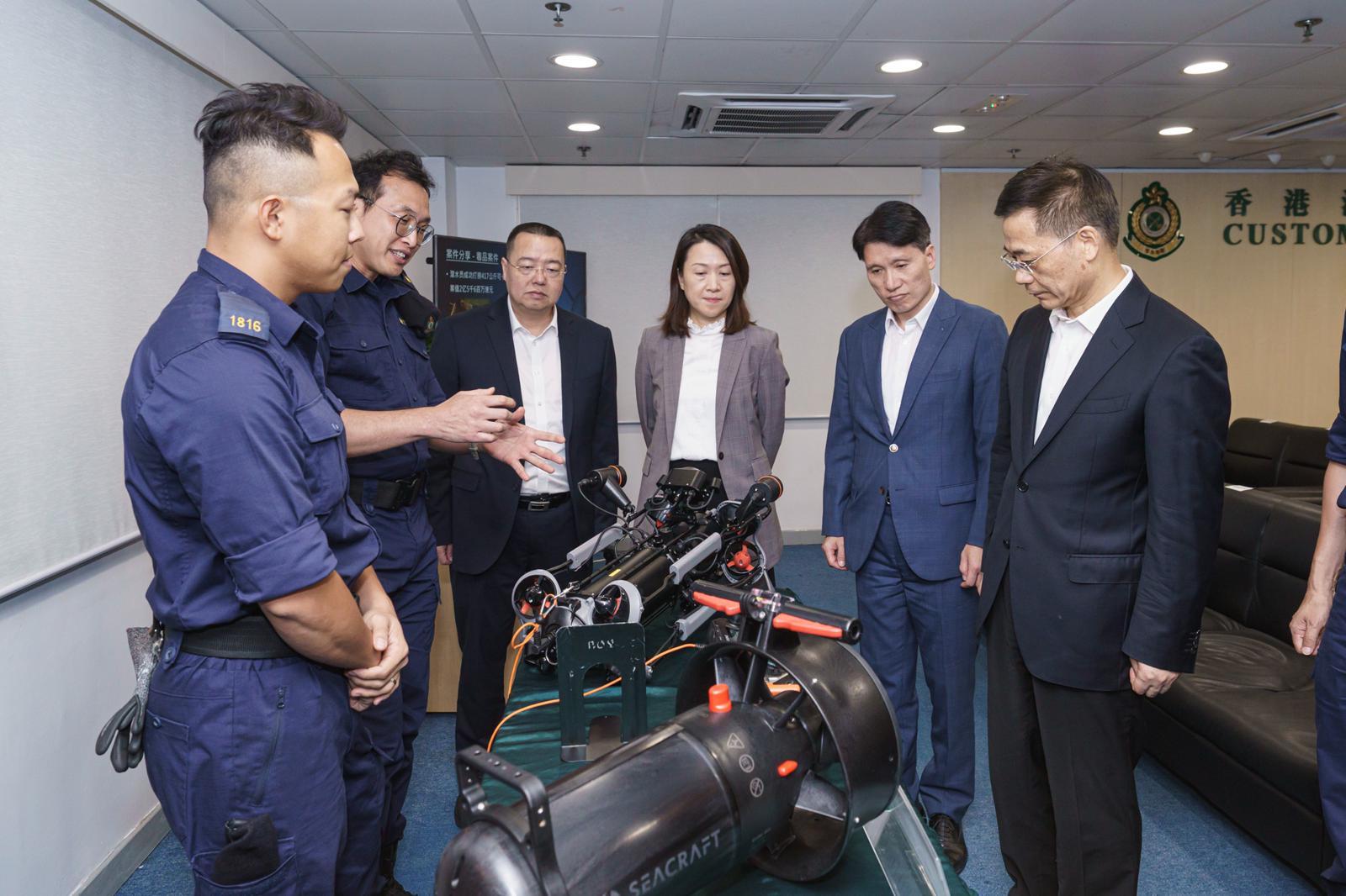 The Commissioner of Customs and Excise, Mr Chan Tsz-tat, today (June 8) welcomed the visit by
the Director General in the Huangpu Customs District, Mr Jin Hai, and his delegation. Photo shows the Deputy Commissioner (Control and Enforcement), Mr Mark Woo (second right), accompanying Mr Jin (first right) to visit the Customs Marine Base on Stonecutters Island.