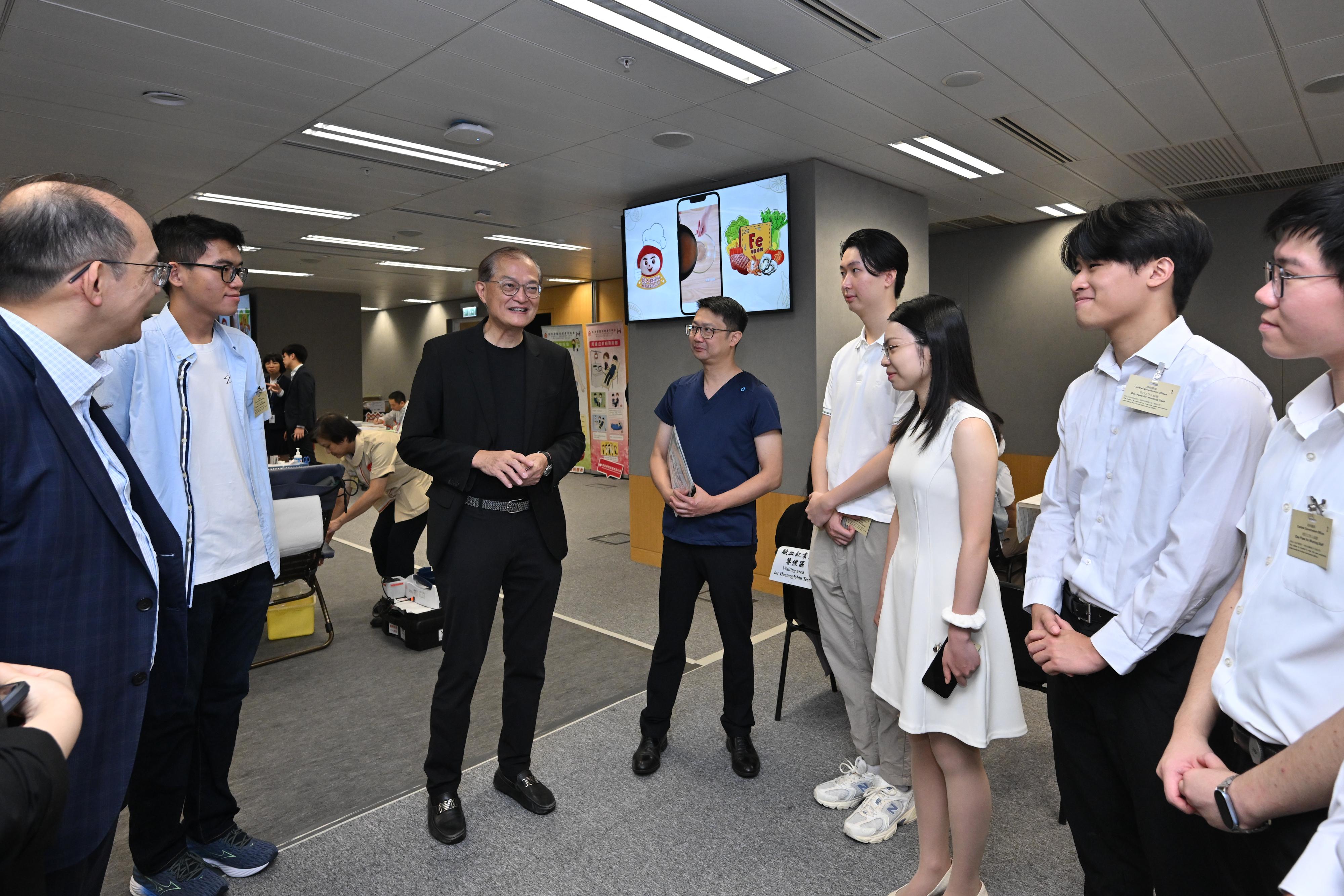 The Secretary for Health, Professor Lo Chung-mau, demonstrated his unwavering support for saving lives through blood donation by participating in the blood donation drive organised by the Hong Kong Red Cross at the Central Government Offices today (June 9). Photo shows Professor Lo (third left) chatting with several medical students at the event. Also accompanying is the Senior Advisor (Secretary for Health's Office), Dr Joe Fan (fourth left).