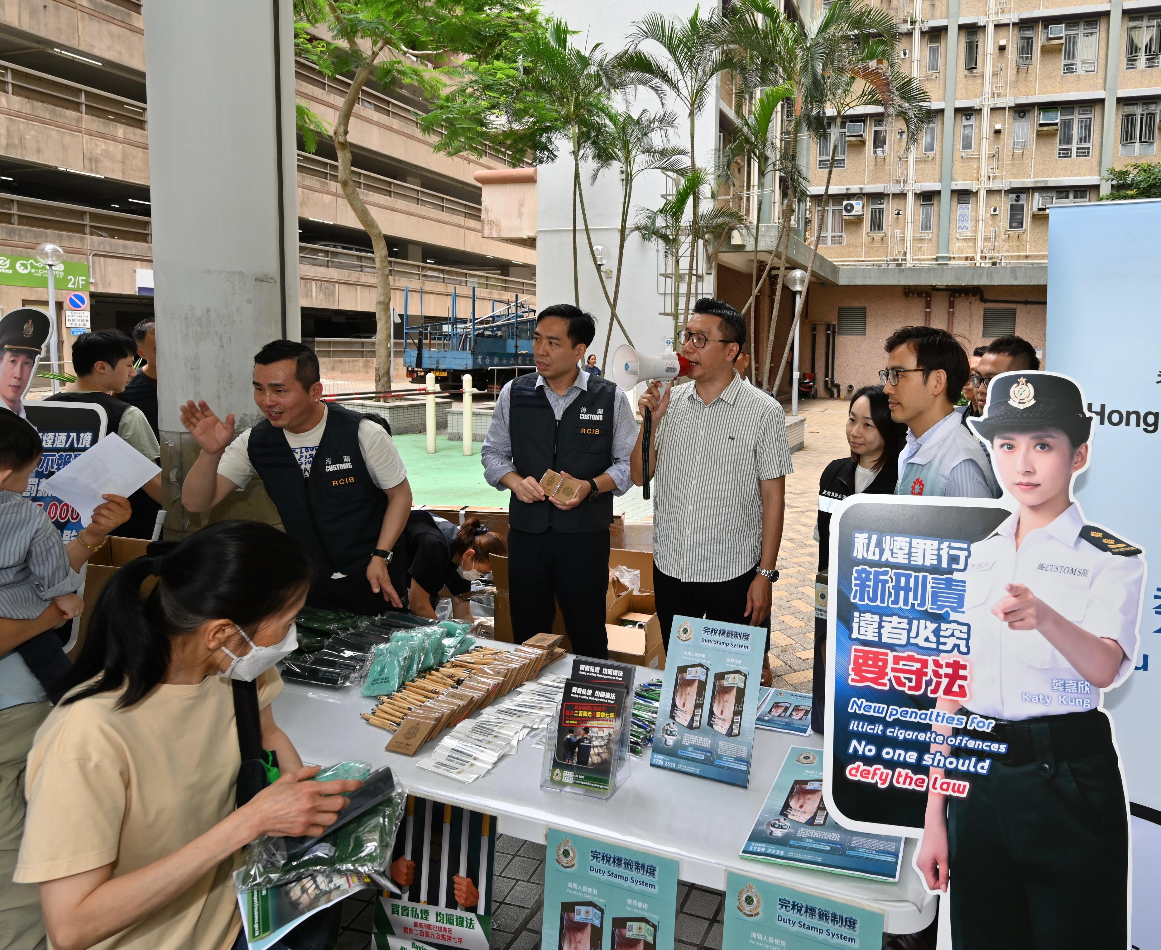 Hong Kong Customs yesterday (June 9) conducted joint anti-illicit cigarette publicity activities with Legislative Council Member Mr Cheung Pui-kong, members of the Kwun Tong District Council, the Tobacco and Alcohol Control Office of the Department of Health, the Hong Kong Police Force and the Housing Department in Tsui Ping (North) Estate and Sau Mau Ping Estate in Kwun Tong. Customs also publicised the Duty Stamp System. Photo shows Customs officers and the Council members promoting anti-illicit cigarette messages to residents.