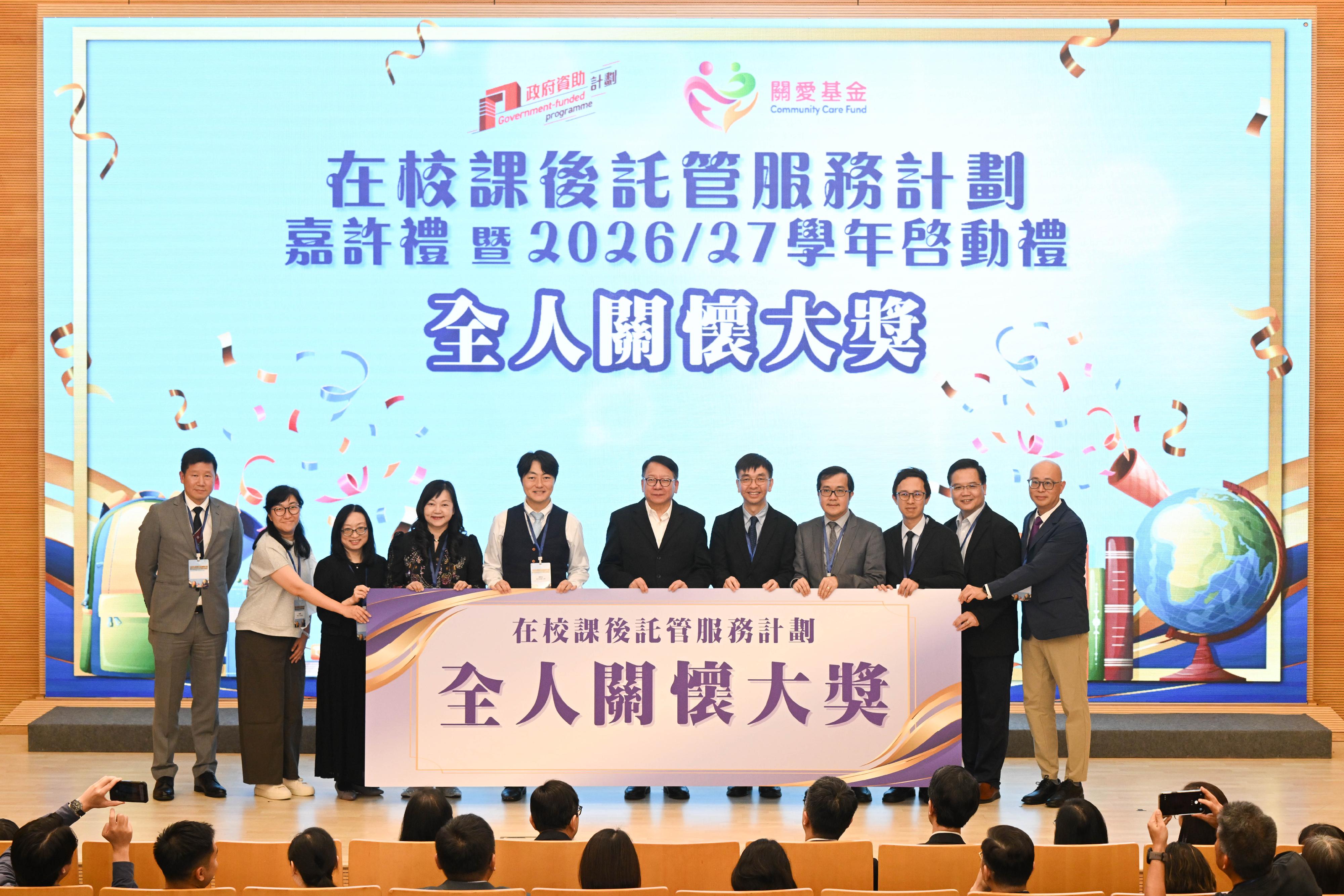 「在校課後託管服務計劃」嘉許禮暨二○二六／二七學年啓動禮今日（六月十一日）圓滿舉行。圖示政務司司長陳國基（左六）與獲獎的學校代表合照。