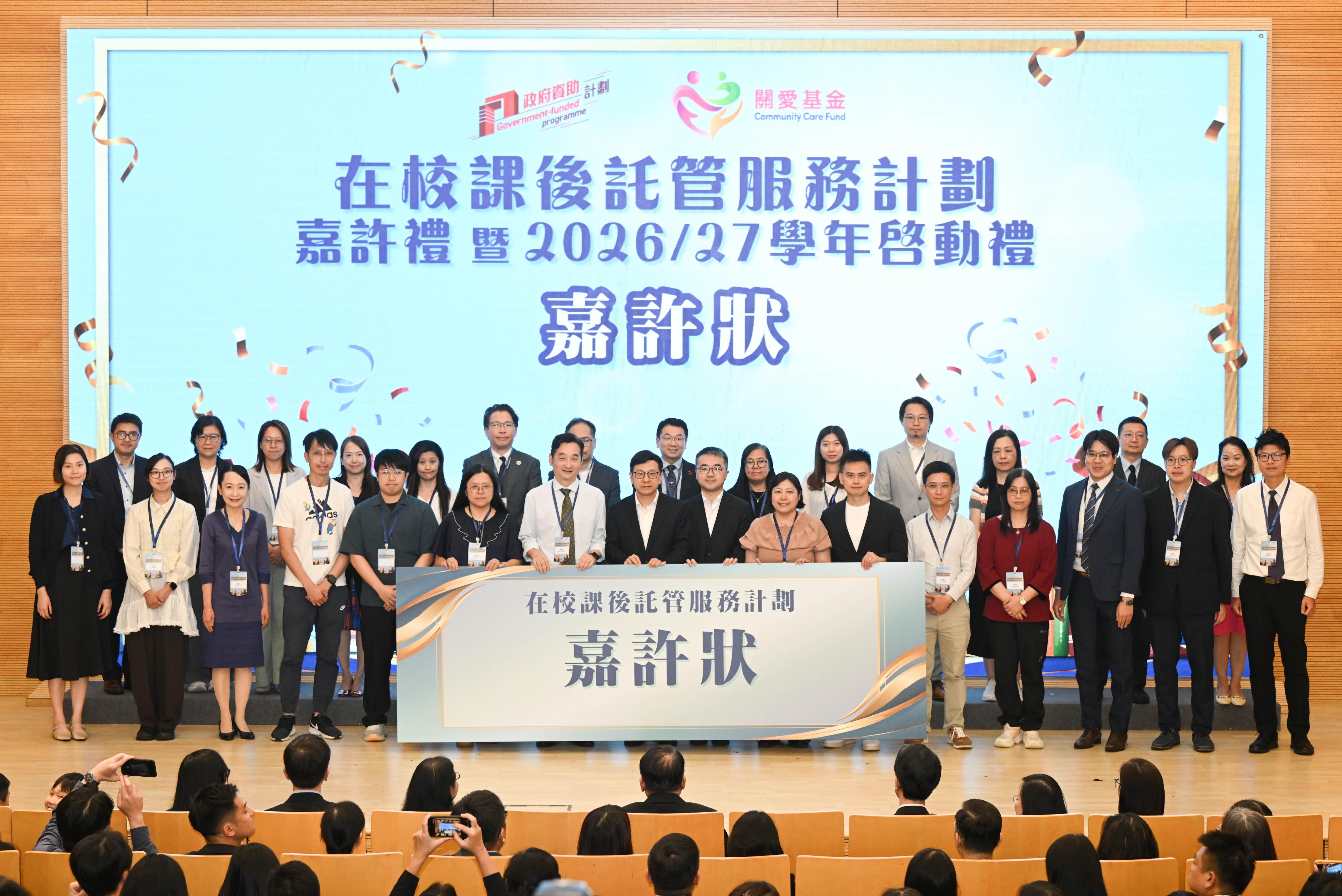 「在校課後託管服務計劃」嘉許禮暨二○二六／二七學年啓動禮今日（六月十一日）圓滿舉行。圖示勞工及福利局局長孫玉菡（前排左八）、教育局副局長施俊輝博士（前排右八）與獲獎的學校代表合照。