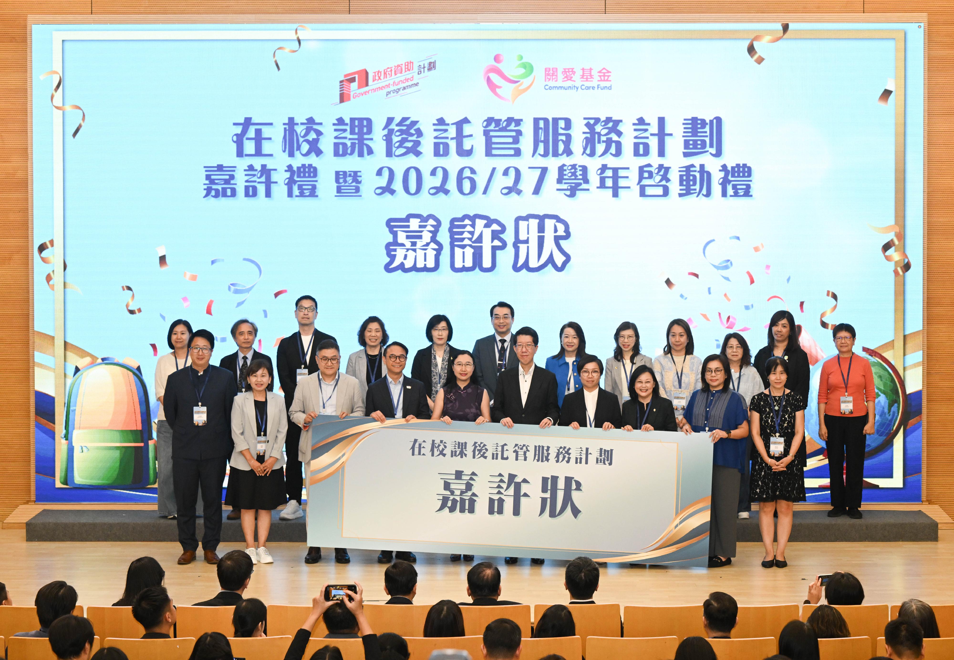 「在校課後託管服務計劃」嘉許禮暨二○二六／二七學年啓動禮今日（六月十一日）圓滿舉行。圖示勞工及福利局常任秘書長劉焱（前排左五）、社會福利署署長杜永恒（前排右五）與獲獎的學校代表合照。