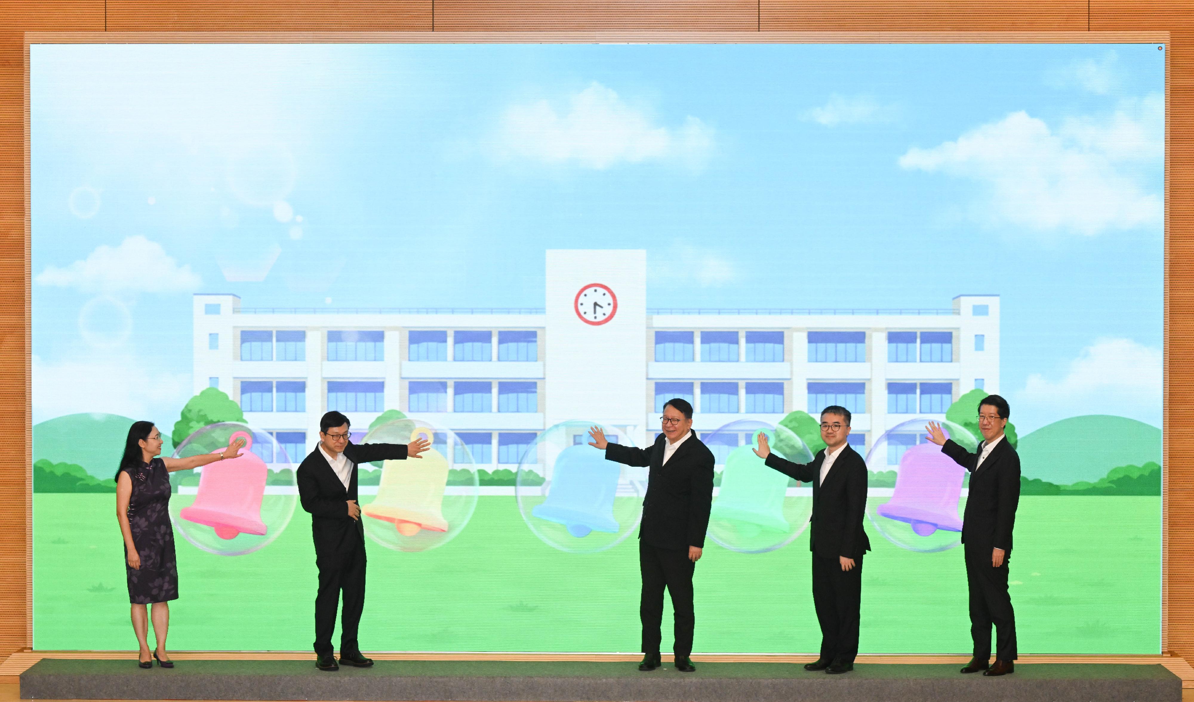 「在校課後託管服務計劃」嘉許禮暨二○二六／二七學年啓動禮今日（六月十一日）圓滿舉行。圖示政務司司長陳國基（中）、勞工及福利局局長孫玉菡（左二）、勞工及福利局常任秘書長劉焱（左一）、教育局副局長施俊輝博士（右二）和社會福利署署長杜永恒（右一）主持啓動儀式。