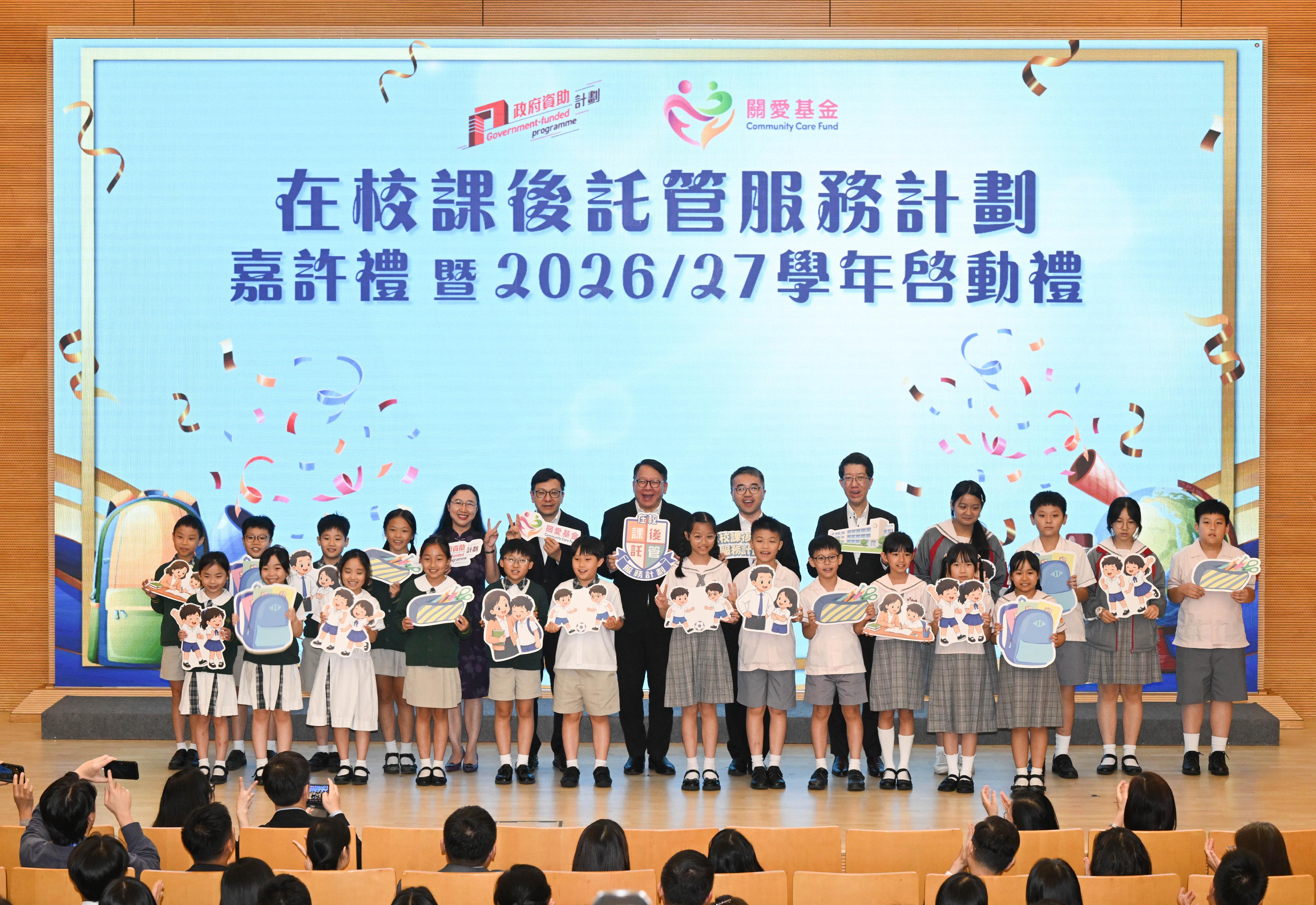 The School-based After School Care Service Scheme commendation ceremony and 2026/27 school year launching ceremony was held today (June 11). Photo shows the Chief Secretary for Administration, Mr Chan Kwok-ki (back row, centre); the Secretary for Labour and Welfare, Mr Chris Sun (back row, sixth left); the Permanent Secretary for Labour and Welfare, Ms Alice Lau (back row, fifth left); the Under Secretary for Education, Dr Sze Chun-fai (back row, sixth right); the Director of Social Welfare, Mr Edward To (back row, fifth right), with students.