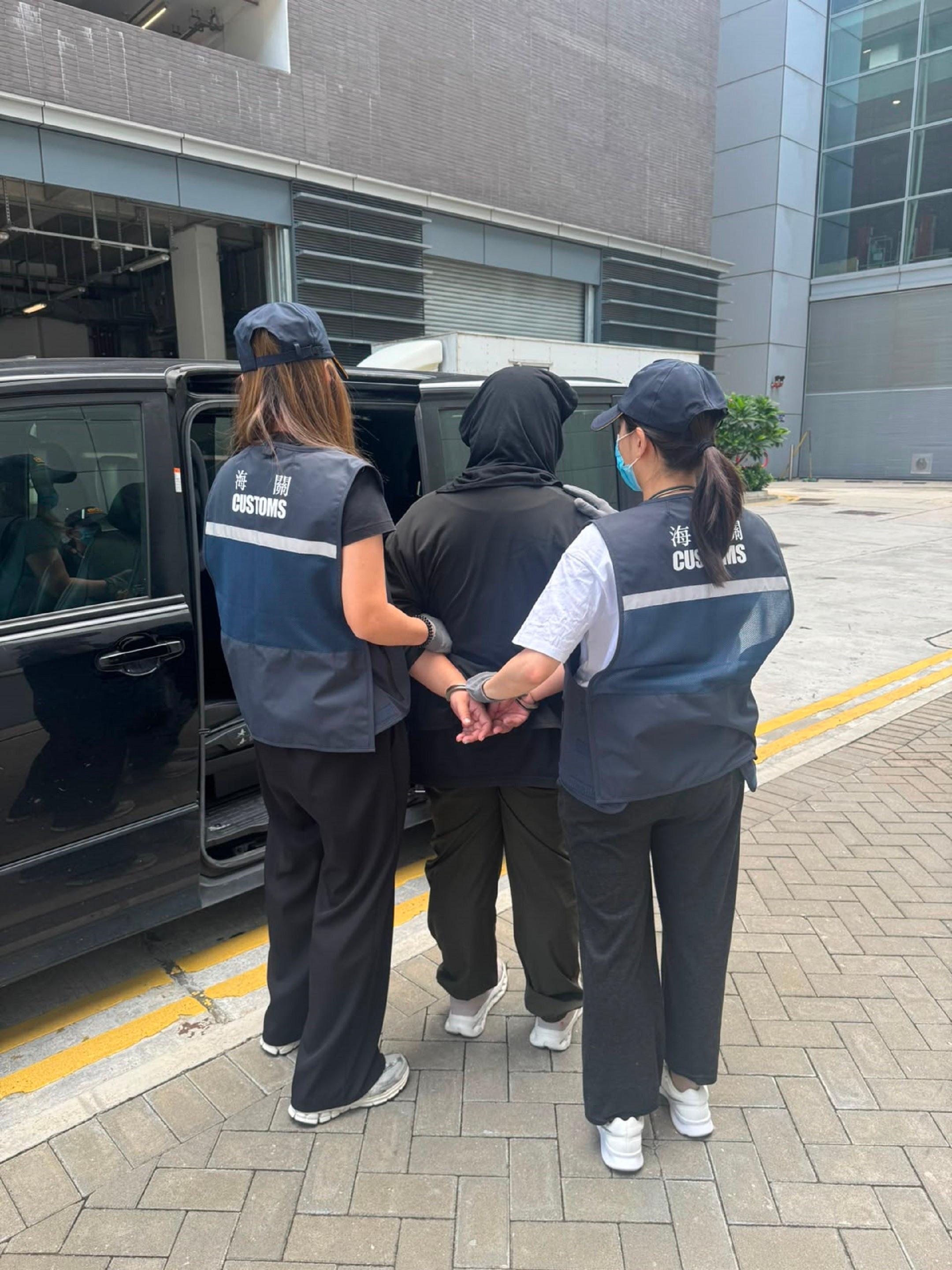香港海關昨日(六月十一日)在香港國際機場偵破一宗涉及航空入境旅客的販毒案件,檢獲約十五公斤懷疑大麻花,估計市值約二百七十萬元。圖示案中的被捕人士(中)。
