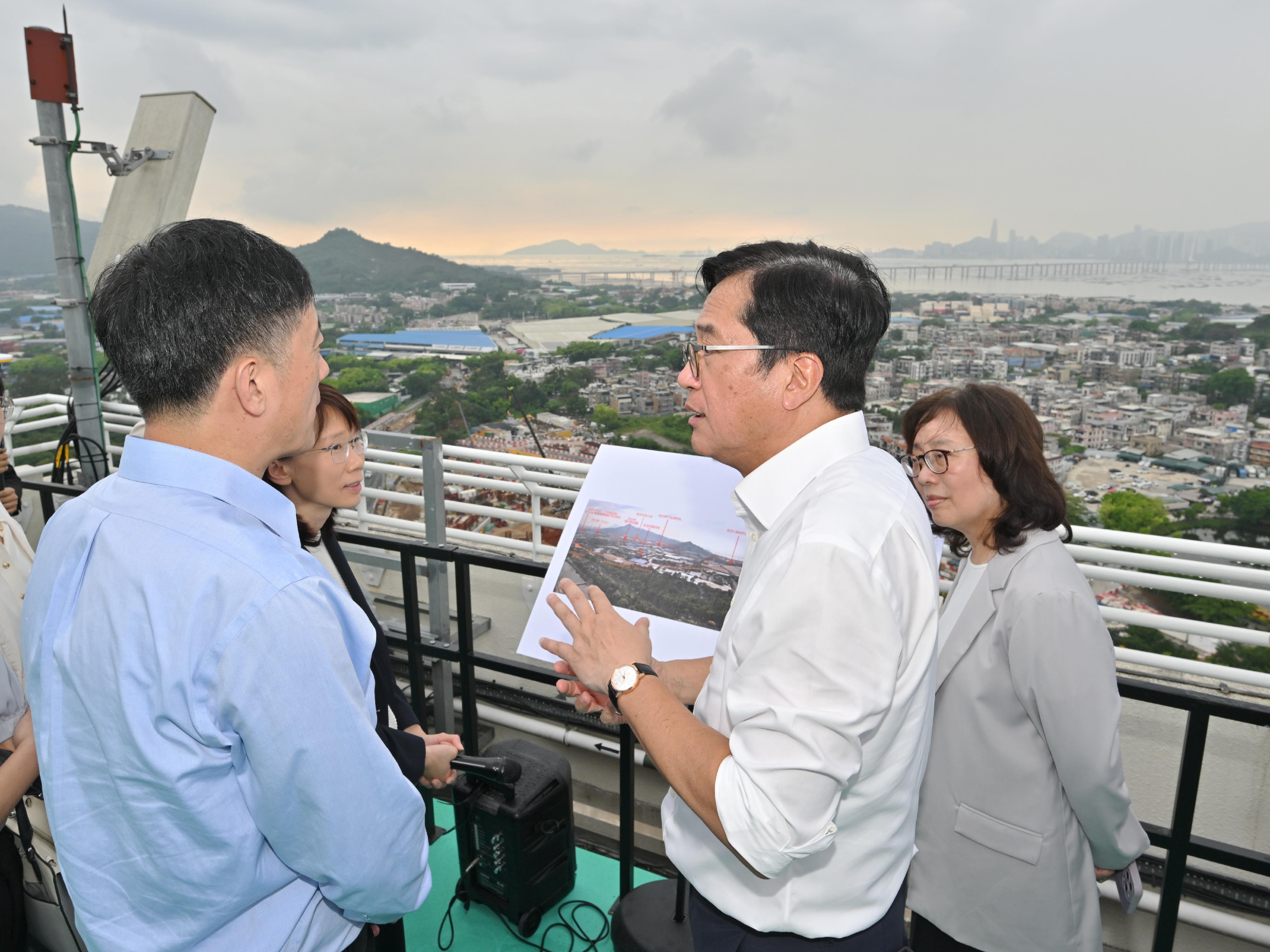 The Deputy Financial Secretary, Mr Michael Wong, and Vice Mayor of the Shenzhen Municipal People's Government Mr Tao Yongxin, leading delegations of the governments of the Hong Kong Special Administrative Region and Shenzhen respectively, held a meeting of the Task Force for Collaboration on the Northern Metropolis Development Strategy in Hong Kong today (June 12). Photo shows Mr Wong (second right), Mr Tao (left), and the HKSAR and Shenzhen delegations getting a bird's eye view of the Hung Shui Kiu/Ha Tsuen area to learn more about the planning of this new development area.