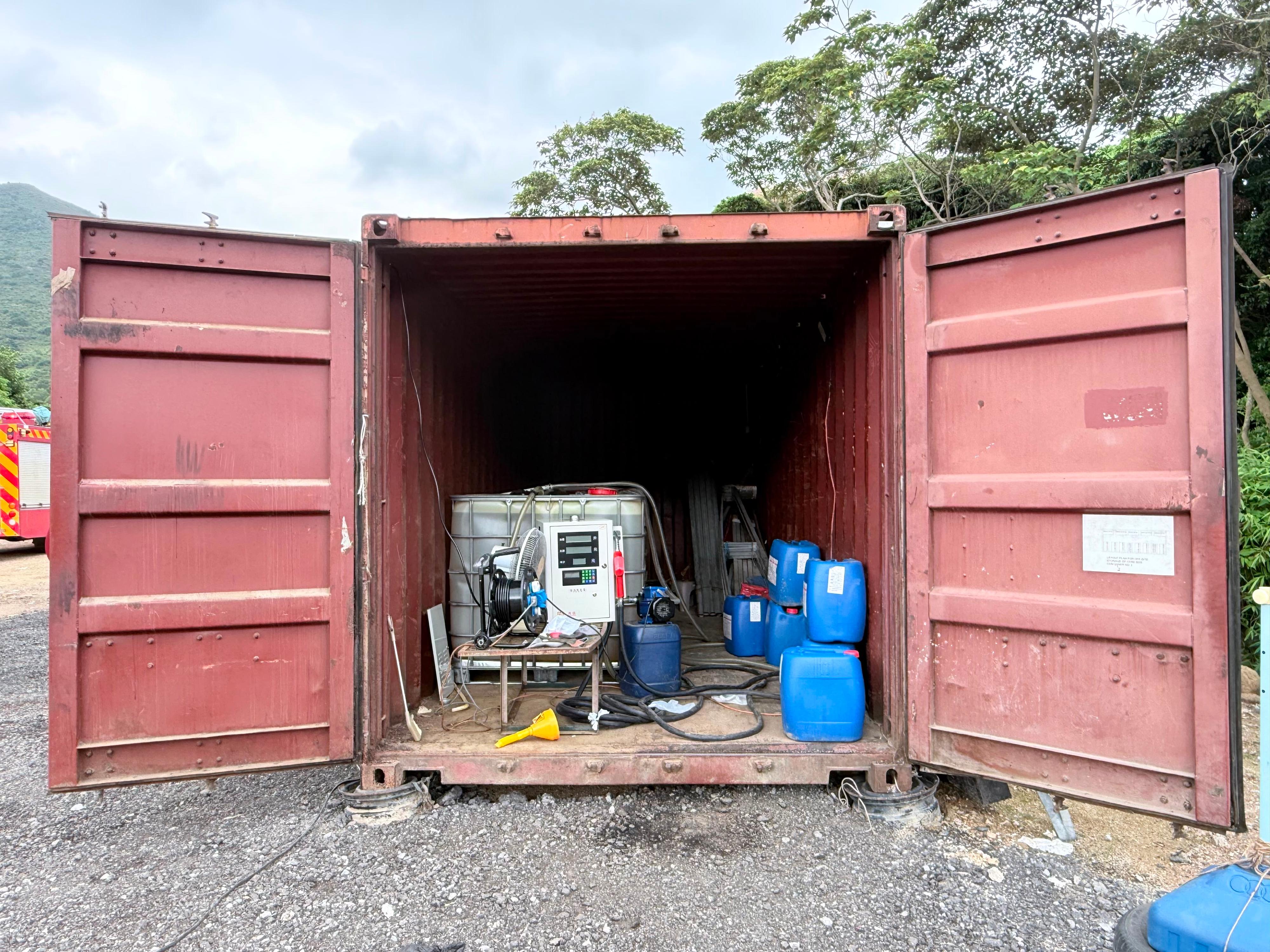 香港海關聯同消防處於六月十日在全港各區進行突擊行動,打擊非法燃油活動。行動中,雙方人員共偵破兩宗相關案件,檢獲共約三千二百公升未完稅汽油,估計市值約十萬四千元,應課稅值約二萬元,並拘捕兩人及檢獲一輛涉案車輛。圖示一個在東涌搗破的非法加油站。
