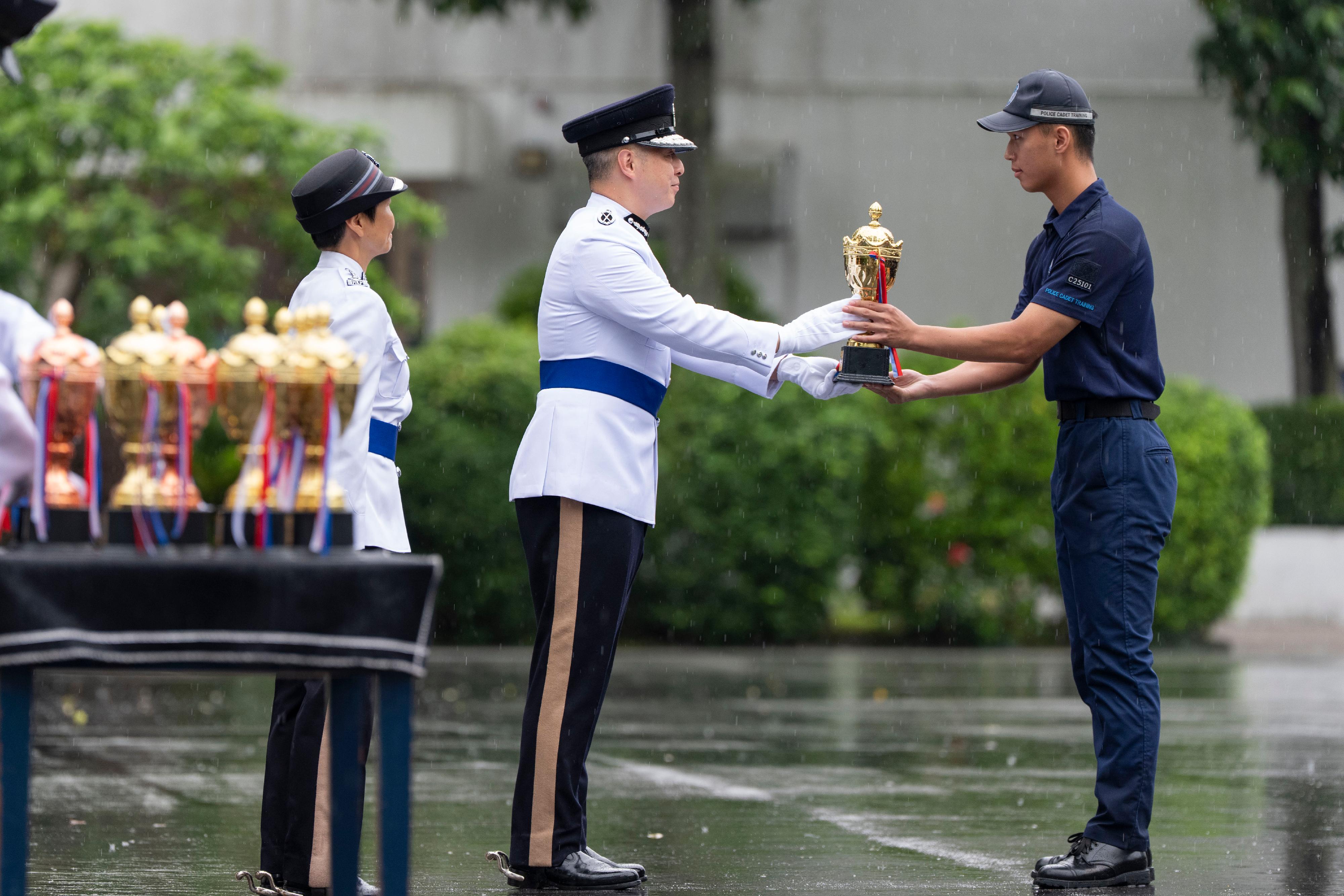 The Commissioner of Police, Mr Chow Yat-ming, inspects a passing-out parade of the Police Cadet Training at the Hong Kong Police College today (June 13), presenting awards to outstanding graduates.