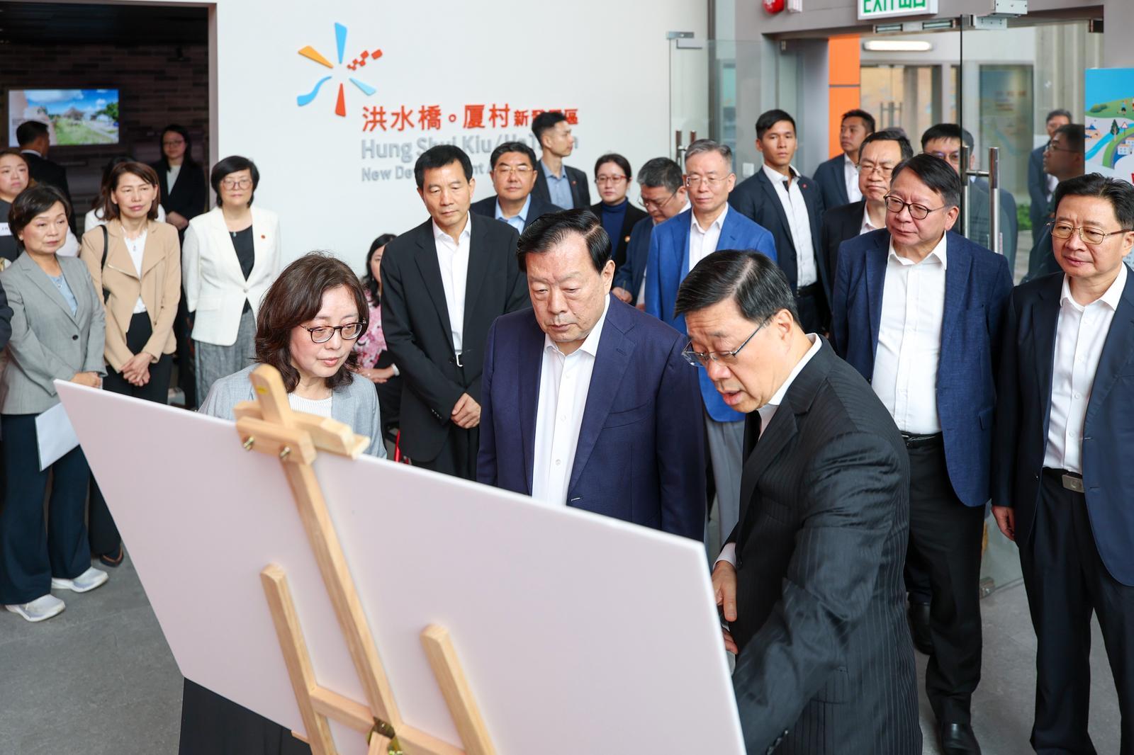The Director of the Hong Kong and Macao Work Office of the Communist Party of China Central Committee and the Hong Kong and Macao Affairs Office of the State Council, Mr Xia Baolong (front row, centre), today (June 16) visits the Hung Shui Kiu/Ha Tsuen New Development Area Community Liaison Centre in the company of the Chief Executive, Mr John Lee (front row, right), and is briefed by the Secretary for Development, Ms Bernadette Linn (front row, left), on the planning and development of the new development area.