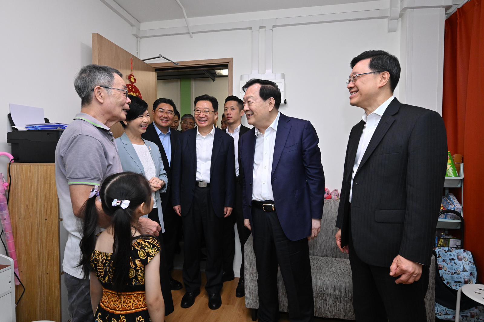 The Director of the Hong Kong and Macao Work Office of the Communist Party of China Central Committee and the Hong Kong and Macao Affairs Office of the State Council, Mr Xia Baolong (second right), today (June 16) visited a family at the Light Public Housing on Yau Pok Road, Yuen Long, in the company of the Chief Executive, Mr John Lee (first right), and the Secretary for Housing, Ms Winnie Ho (third left). Photo shows Mr Xia interacting with the residents.