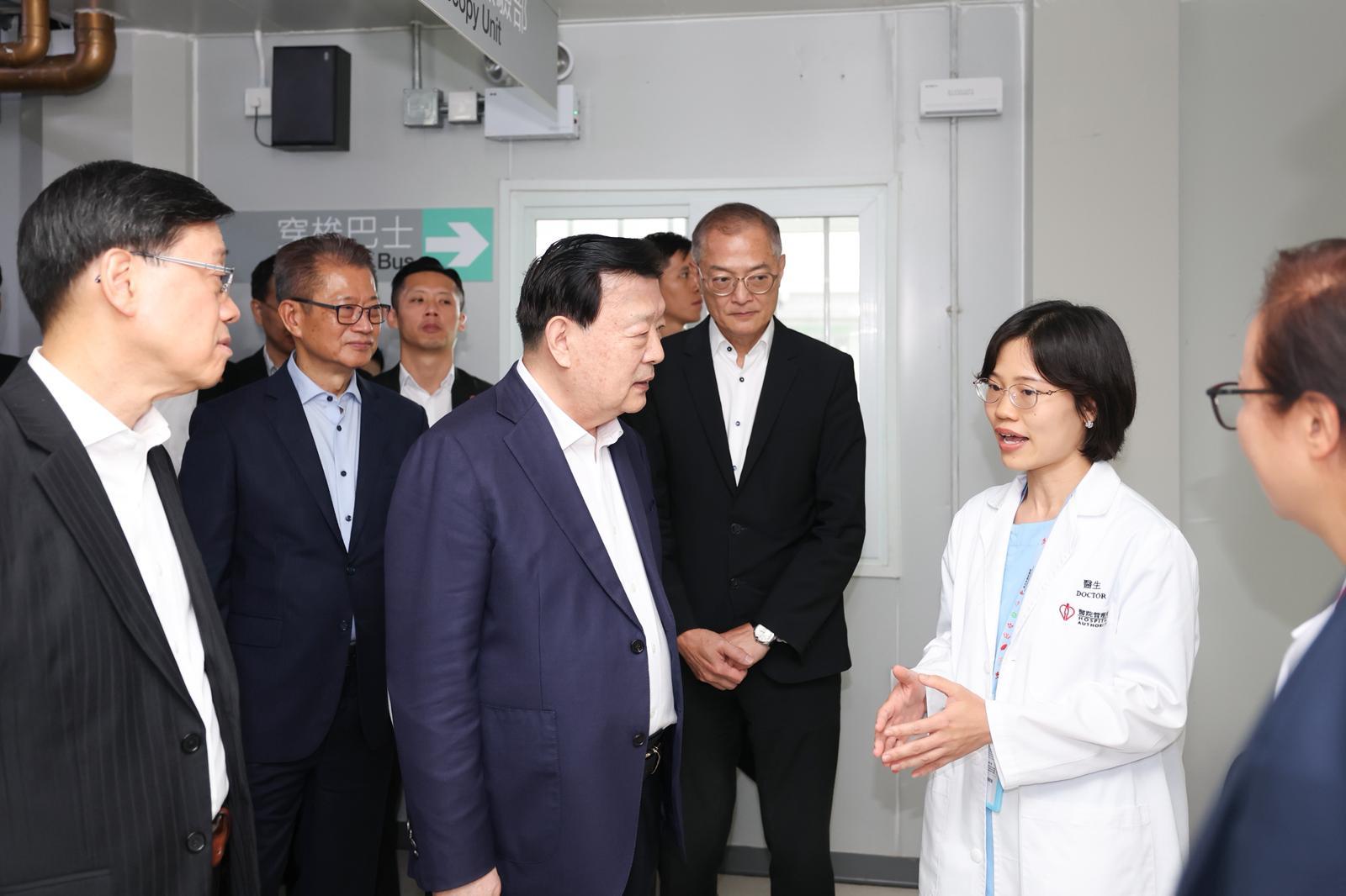 The Director of the Hong Kong and Macao Work Office of the Communist Party of China Central Committee and the Hong Kong and Macao Affairs Office of the State Council, Mr Xia Baolong (third right), today (June 16) visits the Central Government-Aided Emergency Hospital in the Lok Ma Chau Loop in the company of the Chief Executive, Mr John Lee (first left), and exchanges views with the medical staff.