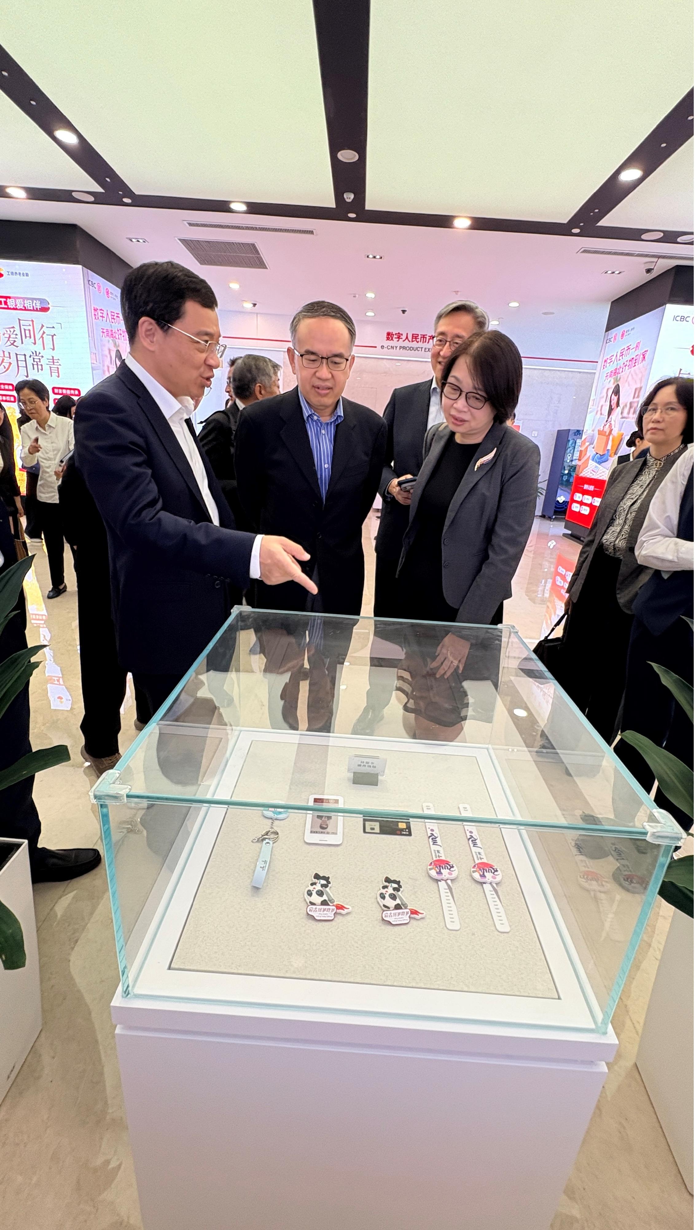 財經事務及庫務局(財庫局)局長許正宇與其率領的金融代表團今日(六月十七日)繼續蘇州訪問行程。圖示許正宇(左二)和財庫局常任秘書長(財經事務)張馮泳萍(右二)到訪中國人民銀行江蘇省分行,聽取該分行行長周誠君(左一)介紹數字人民幣的支付工具。