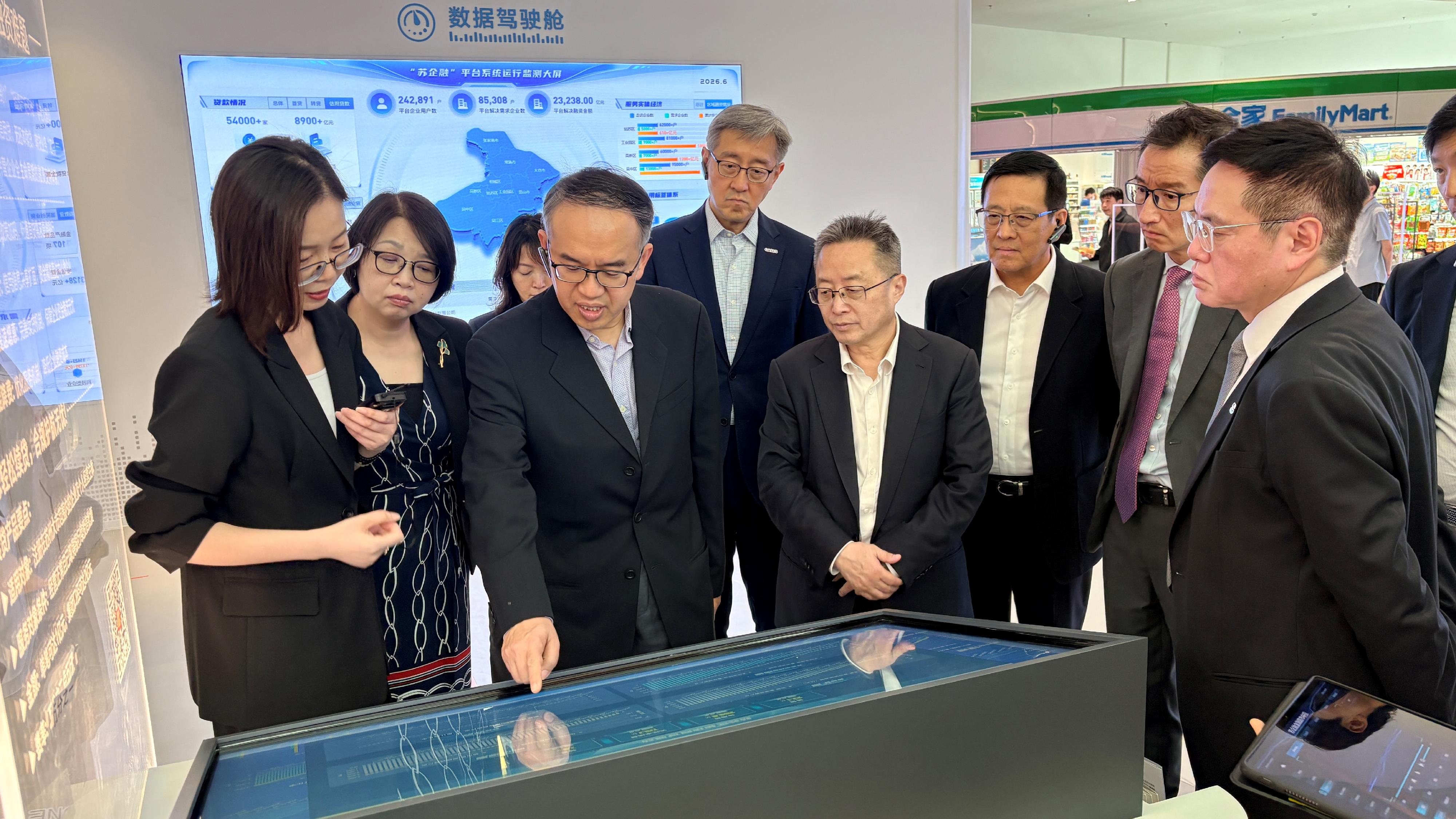 The Secretary for Financial Services and the Treasury, Mr Christopher Hui, and the financial delegation began their visit to Suzhou yesterday (June 16). Photo shows Mr Hui (third left), the Permanent Secretary for Financial Services and the Treasury (Financial Services), Mrs Angelina Cheung (second left), and members of the delegation visiting Jiangsu Jinfu Digital Tech Group Company Limited and receiving a briefing by the Chairman of the Board of the Company, Ms Qiu Xiaolan (first left), on the company's developments in digital finance and AI-driven financial applications. Also present is member of the Standing Committee of the CPC Suzhou Municipal Committee and Executive Vice Mayor of the Suzhou Municipal People's Government, Jiangsu Province, Mr Gu Haidong (fifth left).