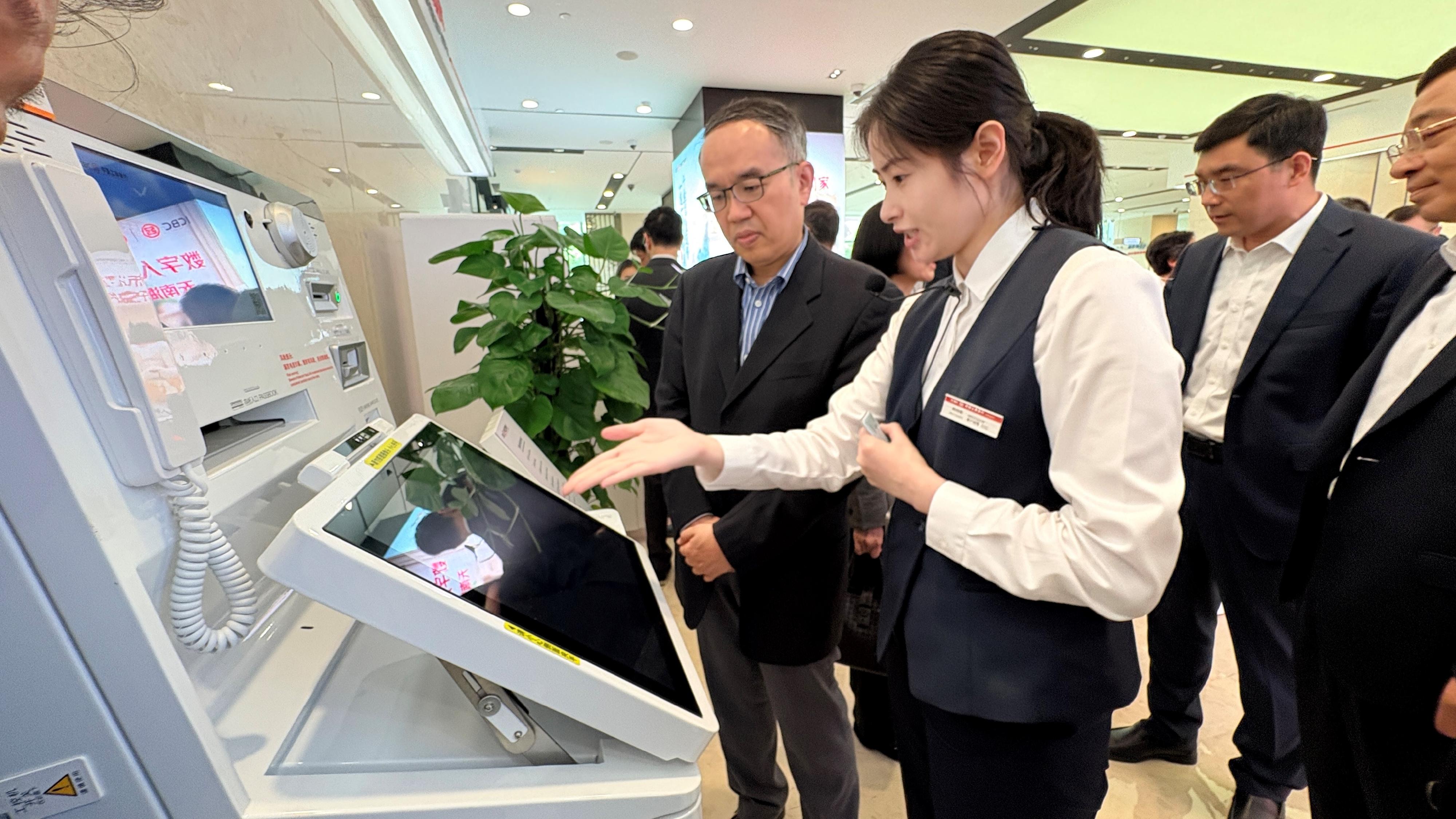The Secretary for Financial Services and the Treasury, Mr Christopher Hui, and the financial delegation continued their visit to Suzhou today (June 17). Photo shows Mr Hui (first left) and members of the delegation being briefed on the operation of the AI-applied intelligent teller machine during their visit to the Jiangsu Branch of the People's Bank of China.
