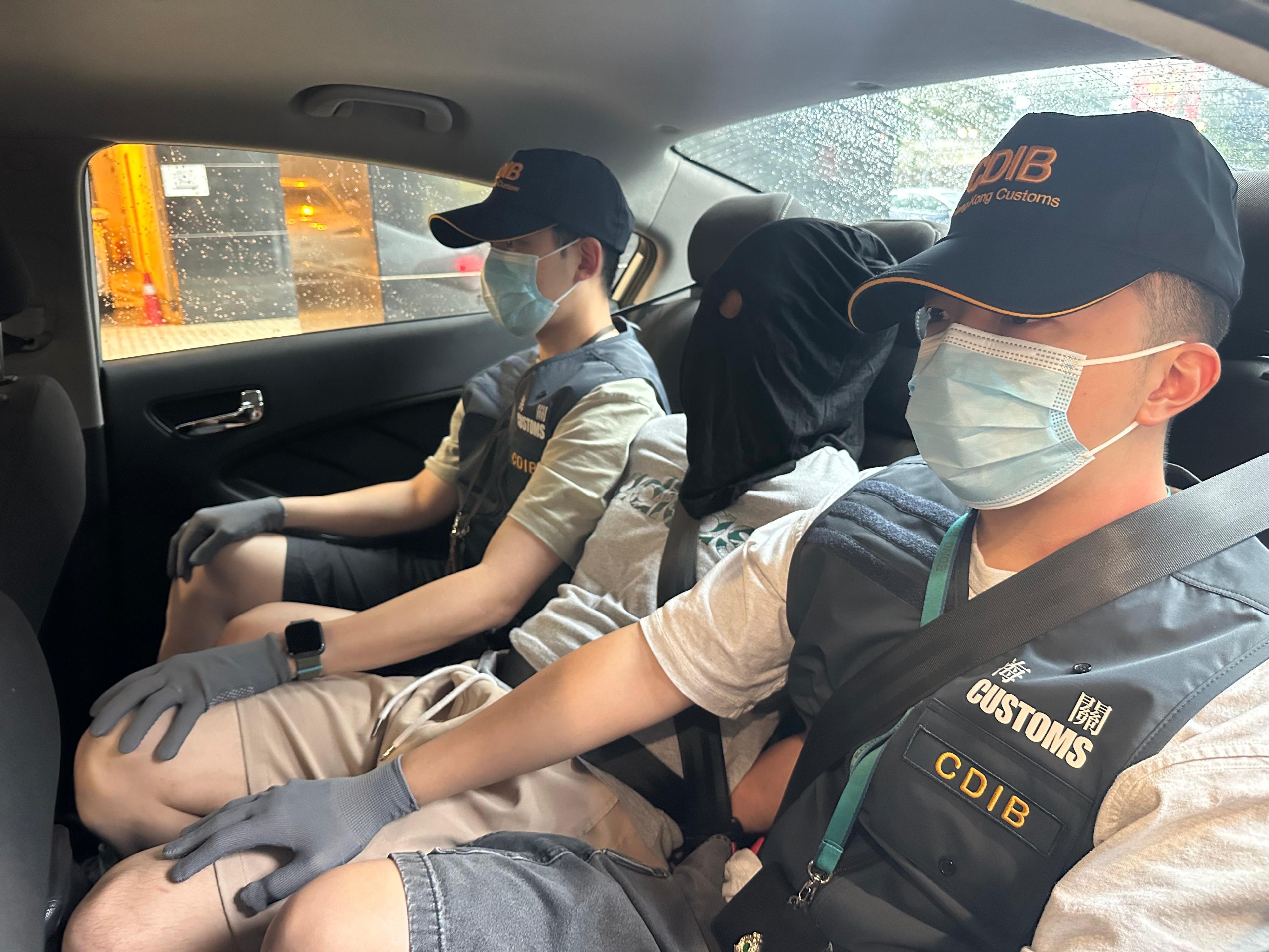 Hong Kong Customs seized about 81.2 kilograms of suspected cannabis buds with an estimated market value of about $14.5 million at Hong Kong International Airport on June 14. Photo shows a local man (centre), who was suspected to be connected with the case.