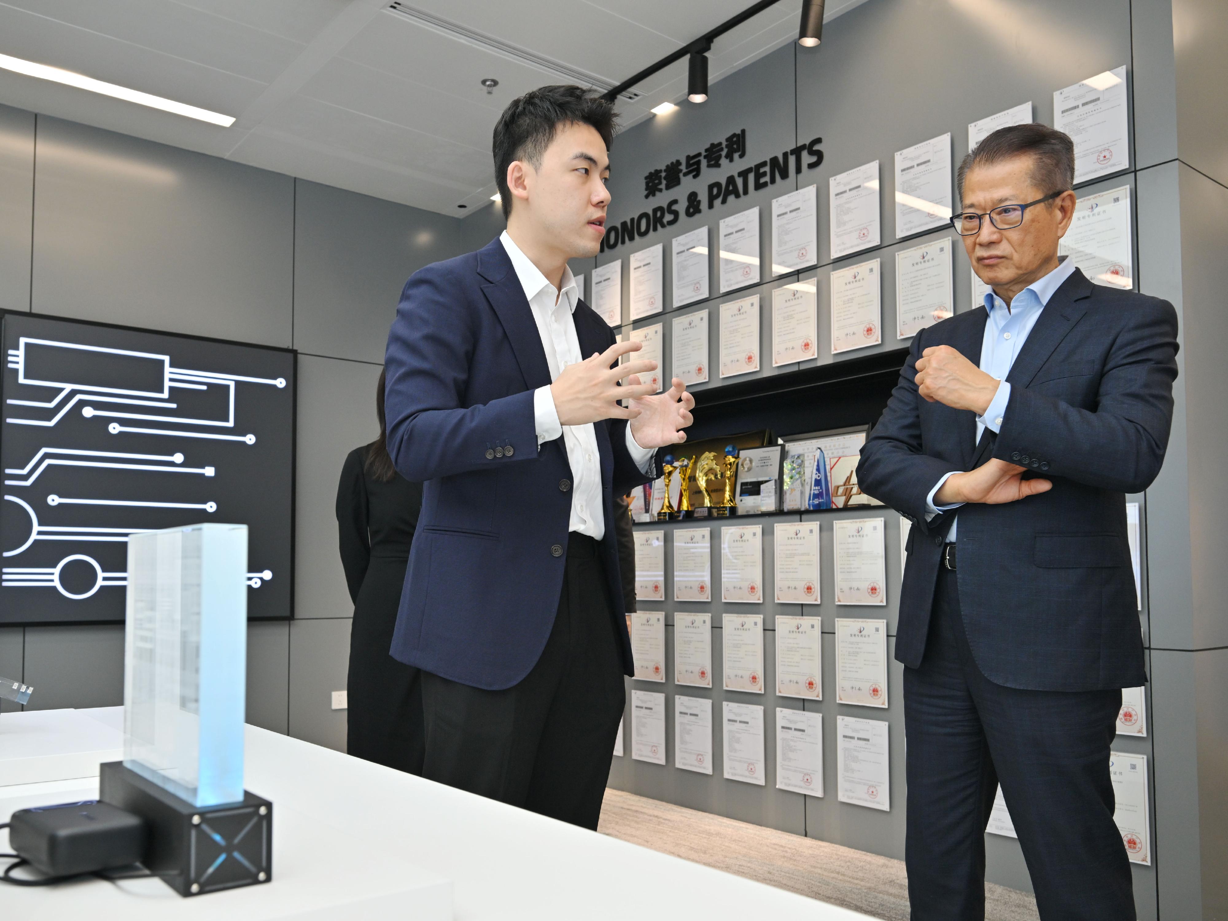 The Financial Secretary, Mr Paul Chan, continued his visit to Shanghai today (June 18). Photo shows Mr Chan (second left) visiting Lightstandard Company Limited and receiving a briefing by the company's Director Mr Xiong Yinjiang on the latest products.
