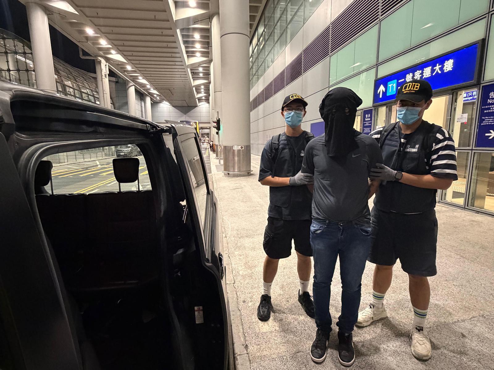 香港海關昨日(六月二十日)和及今日(六月二十一日)在香港國際機場破獲三宗旅客販運毒品的案件,檢獲約二十九公斤懷疑氯胺酮及二點八五公斤懷疑可卡因,估計市值約一千三百萬元,並拘捕三名人士。圖示首宗案件中的涉案的一名被捕人士(中)。