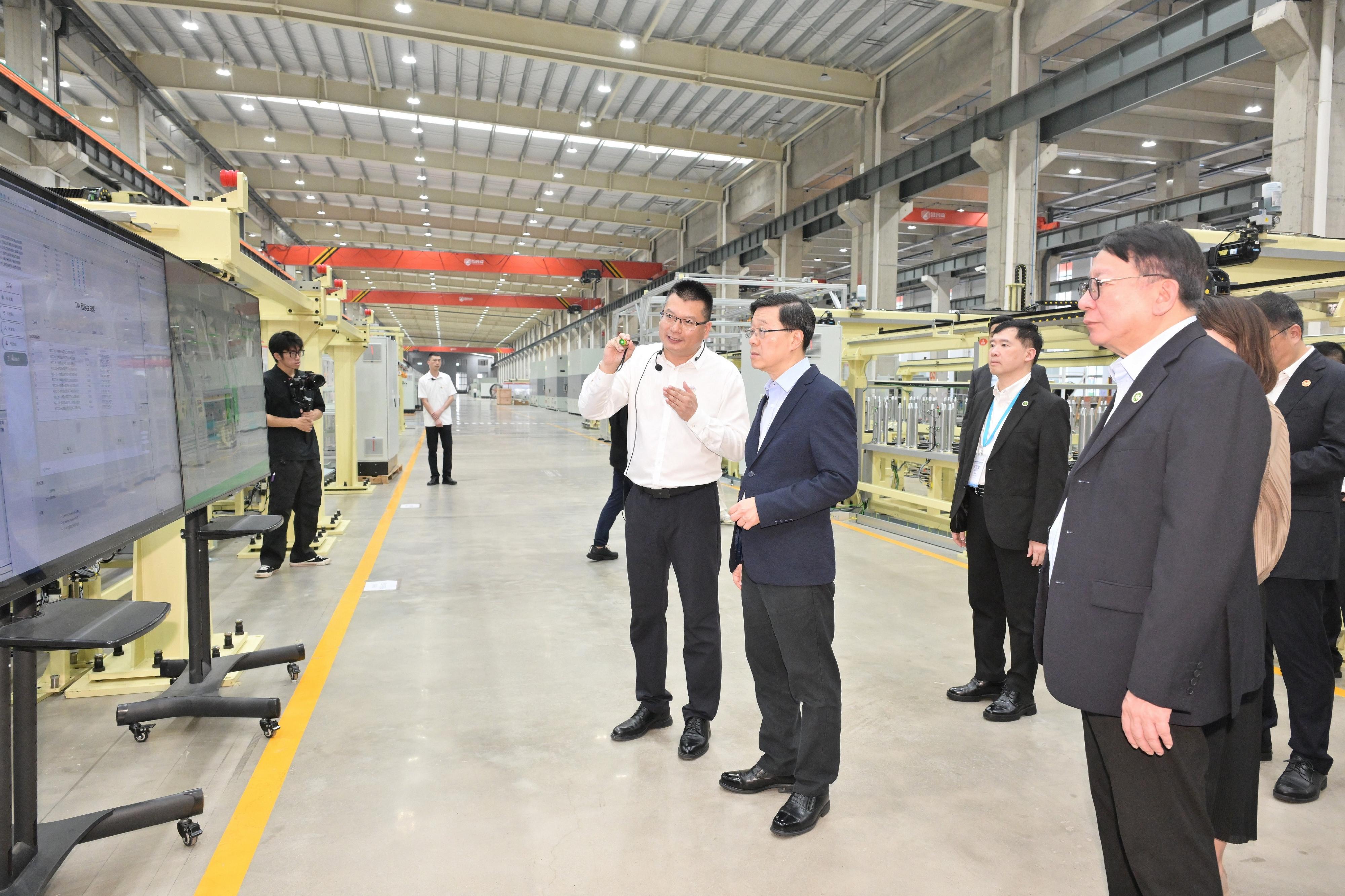 The Chief Executive, Mr John Lee, visited the Ningde Sikeqi Intelligent Equipment Co, Ltd in Fujian today (June 24). Photo shows Mr Lee (second left) being briefed by a company representative.