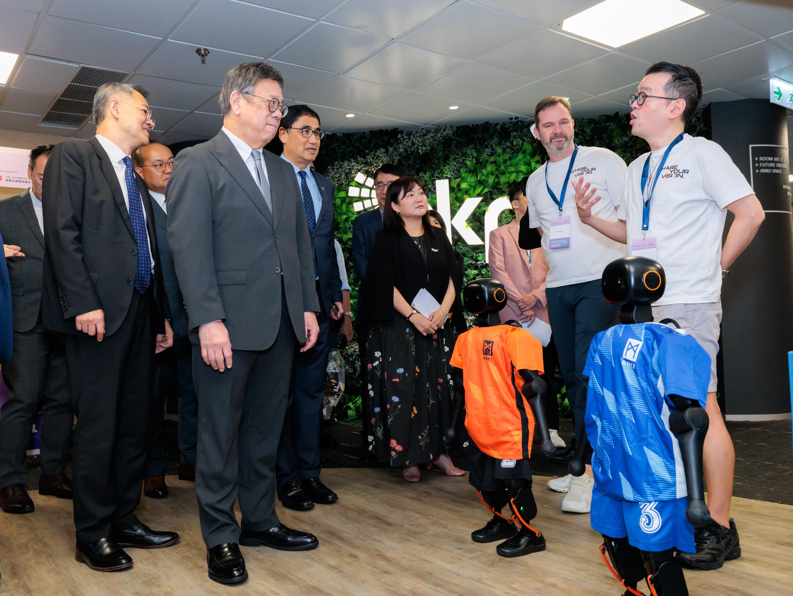 The Secretary for Commerce and Economic Development, Mr Algernon Yau (front row, second left), visits a booth in the Smart Operations thematic zone at the "E-commerce Innovation Expo 2026 - Expanding Brand Horizons" today (June 25). Looking on is the Director-General of Trade and Industry, Mr Aaron Liu (front row, first left).

