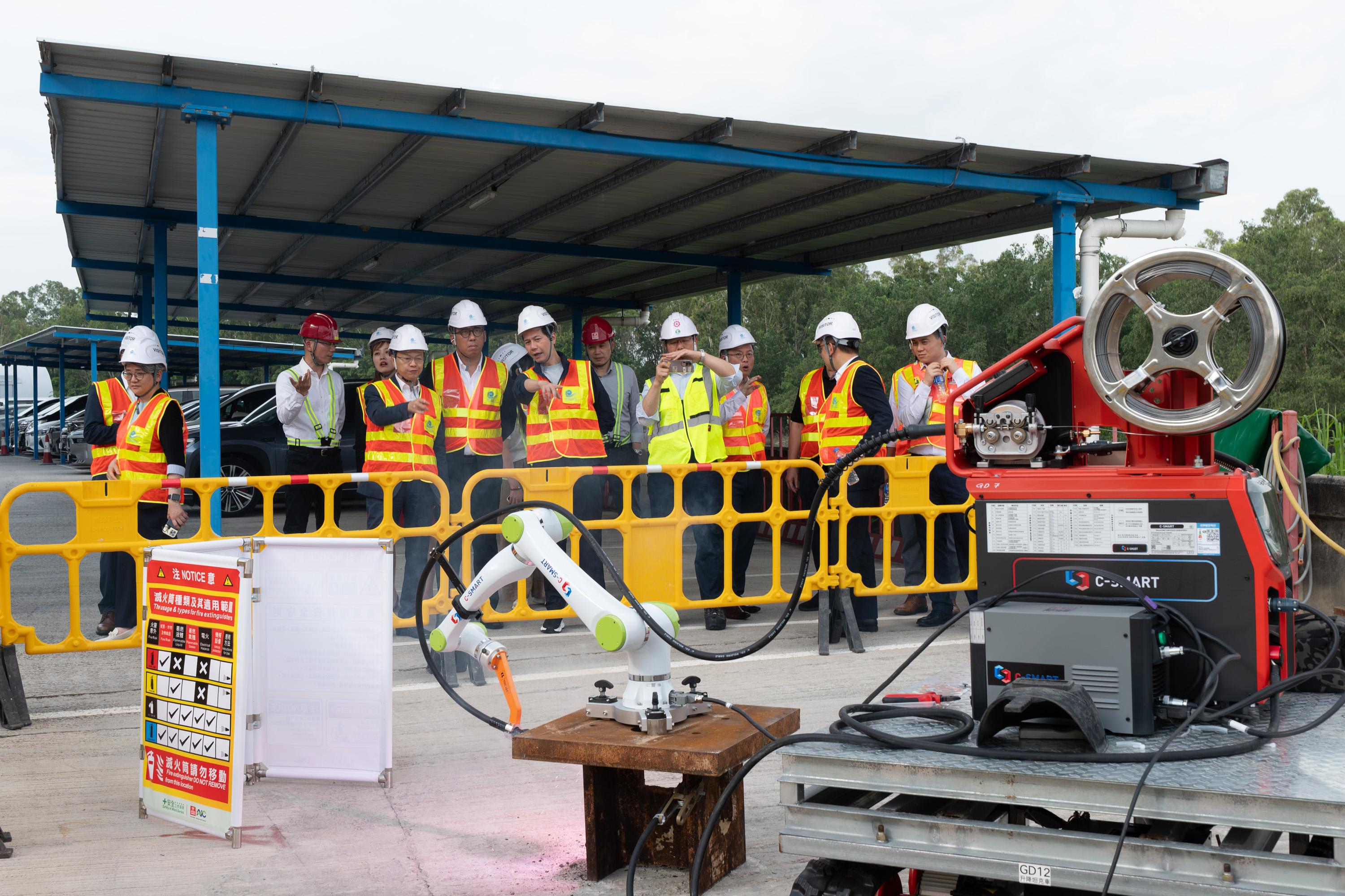 The Legislative Council Subcommittee on Matters Relating to the Development of Artificial Intelligence and Robotics visits the construction site of Yuen Long Barrage and Nullah Improvement Schemes Project today (June 25). Photo shows Members observing the demonstration of welding robots.
