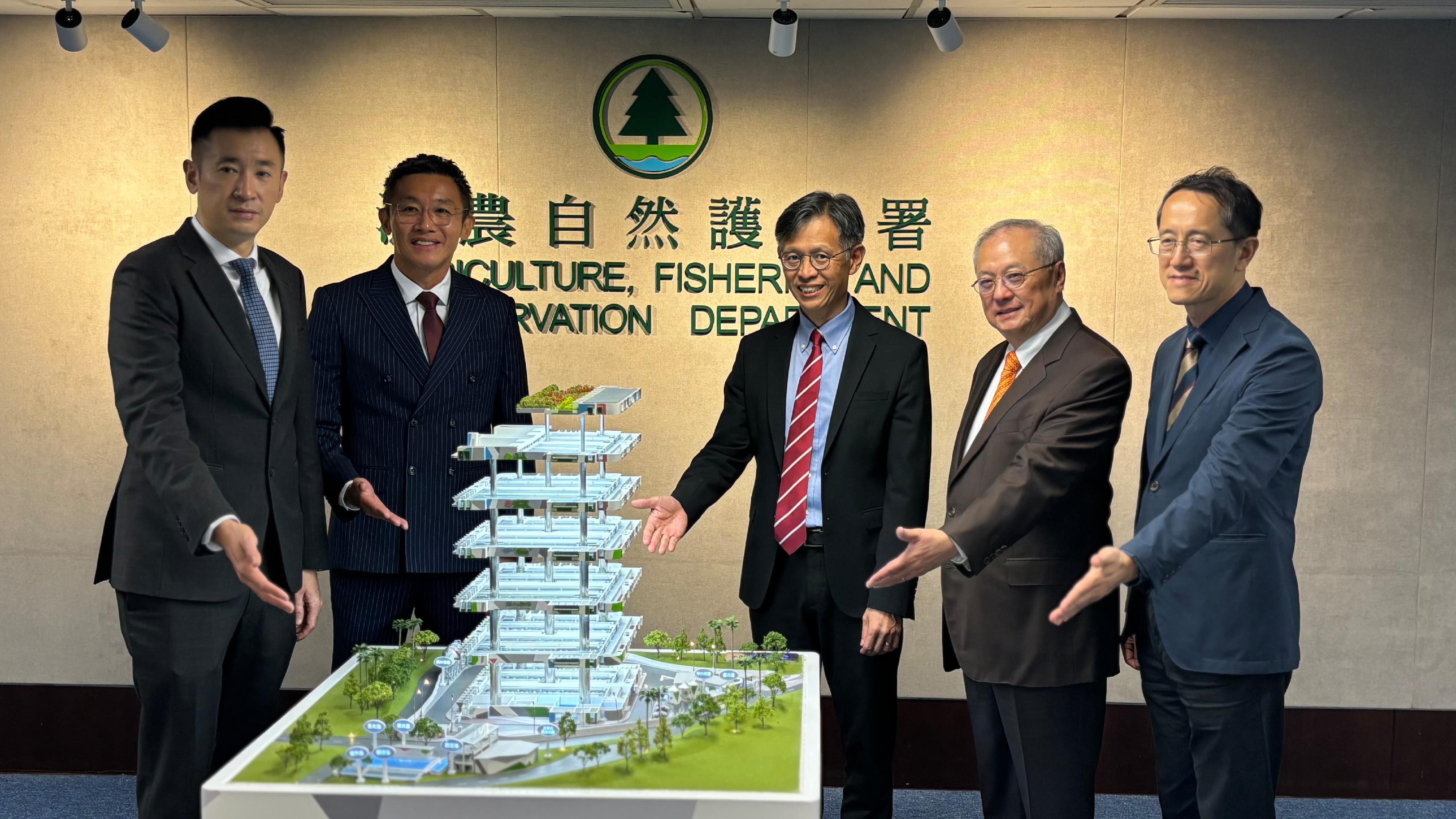 漁農自然護理署（漁護署）今日（六月二十六日）公布，建華農牧（香港）有限公司獲選為香港首個多層式現代化環保養豬場項目的建造及營運機構。圖示漁護署署長黎堅明（右三）、建華農牧（香港）有限公司主席凌偉業（左二）與其他代表於首個多層式現代化環保養豬場項目獲選機構公告典禮上合照。