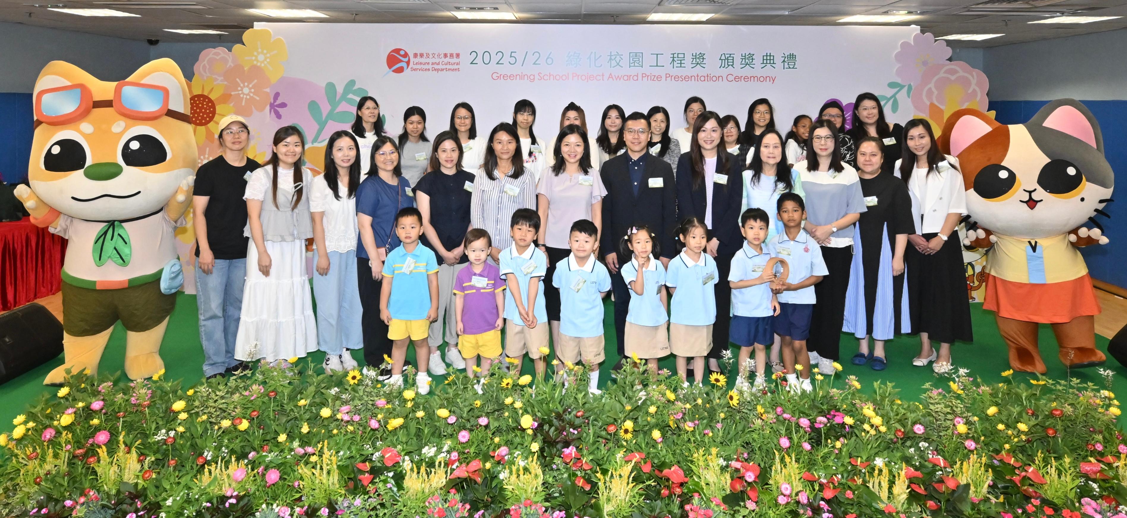 The Greening School Project Award prize presentation ceremony, organised by the Leisure and Cultural Services Department, was held today (June 27) at the Kowloon Park Sports Centre. Thirty-seven schools were commended for their meritorious green school projects and contributions to environmental greening. Photo shows the officiating guests with some winners of the Award.
