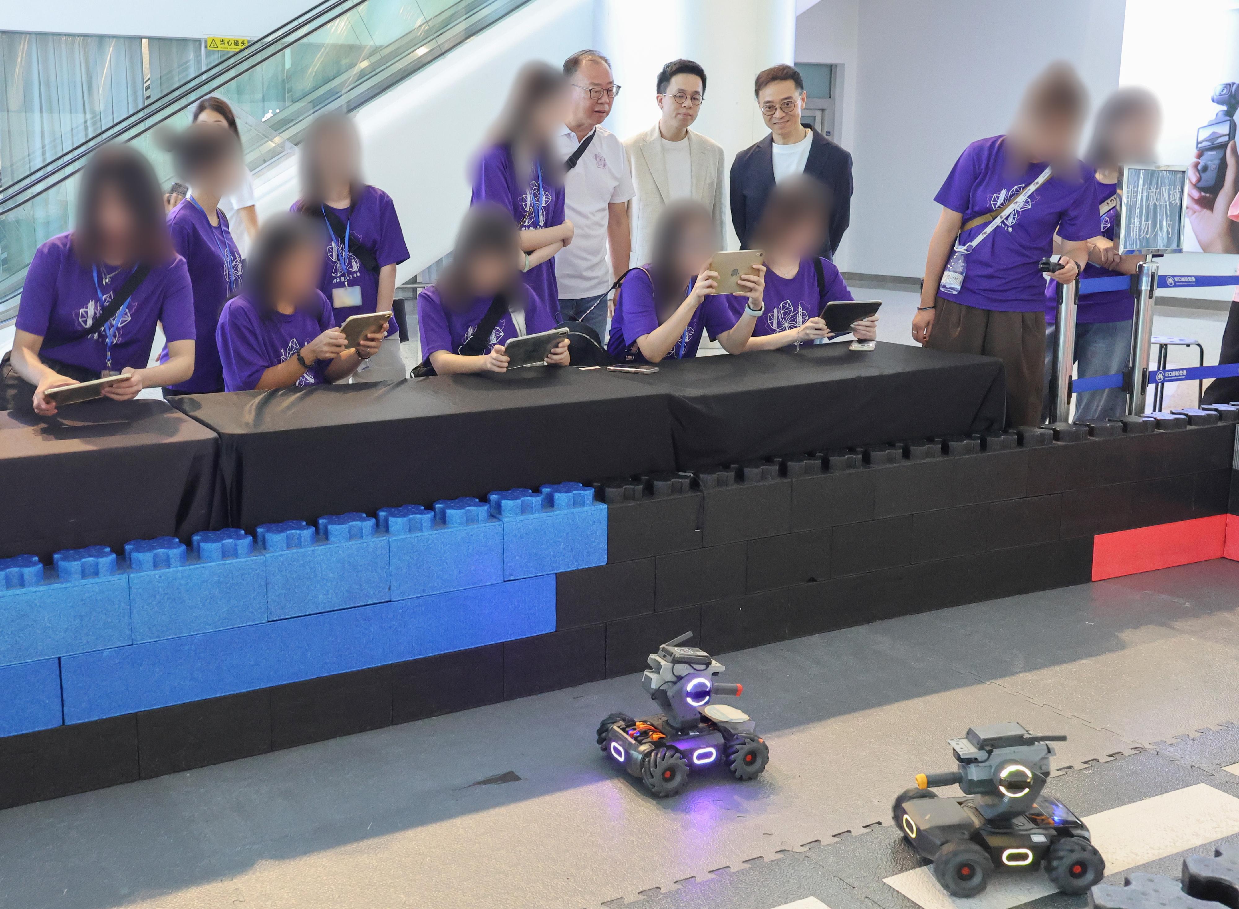 The Correctional Services Department organised another three-day Greater Bay Area Experience Exchange Tour from June 26 to today (June 28), taking young rehabilitated persons to visit various enterprises and places in Shenzhen to learn about the latest developments in innovation and technology in the Guangdong-Hong Kong-Macao Greater Bay Area, as well as the local history and culture. Photo shows young rehabilitated persons, led by the Commissioner of Correctional Services, Mr Wong Kwok-hing (back row, first right) and the tour's sponsor, Mr Kan Kai-wang (back row, second right), experiencing intelligent educational robot operation at Dajiang Innovations Technology Company Limited on June 27.
