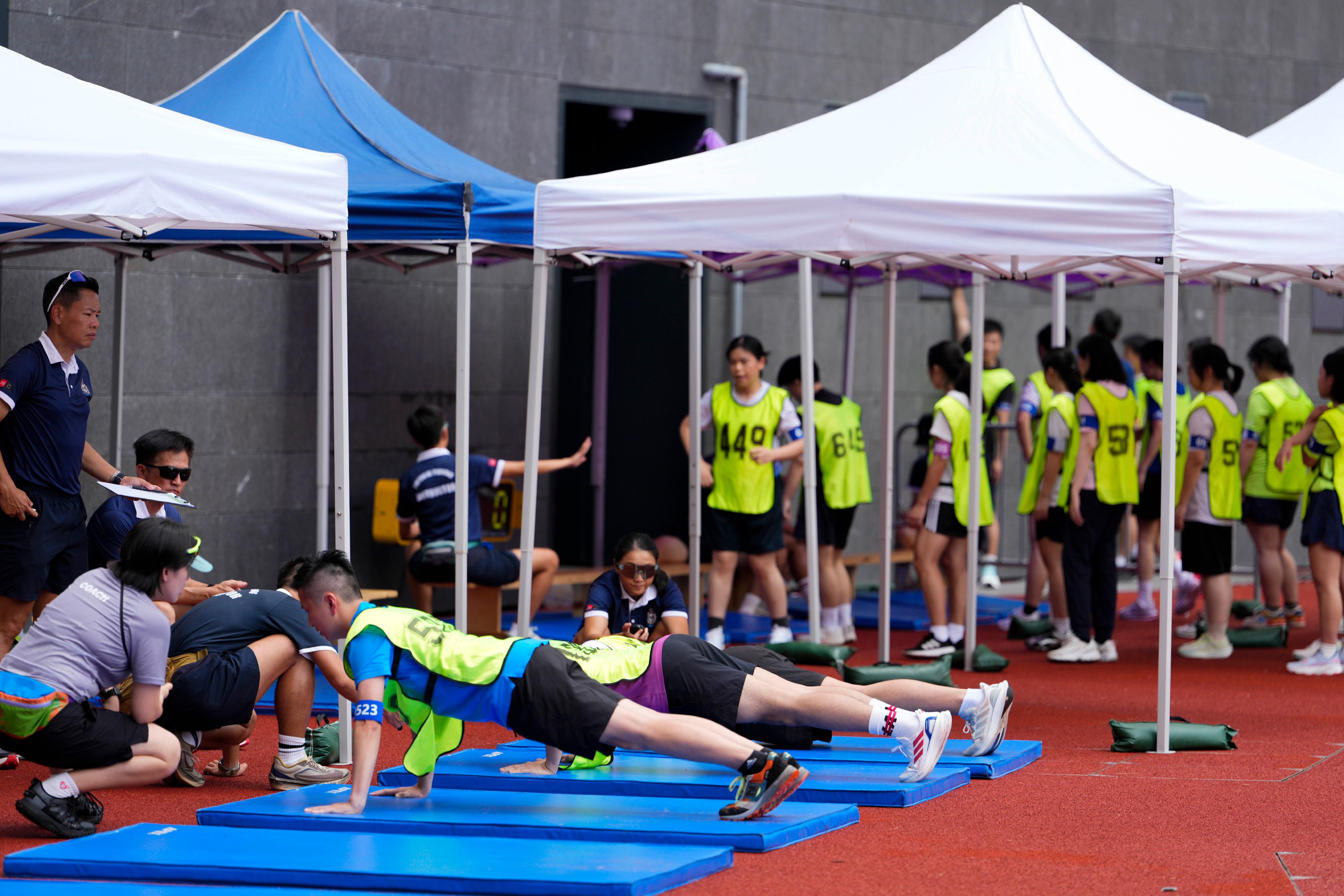 The Hong Kong Police Force today (June 28) held the Police Recruitment Day 2026 at the Kai Tak Youth Sports Ground. Photo shows candidates participating in the push-up assessment as part of the physical fitness test.
