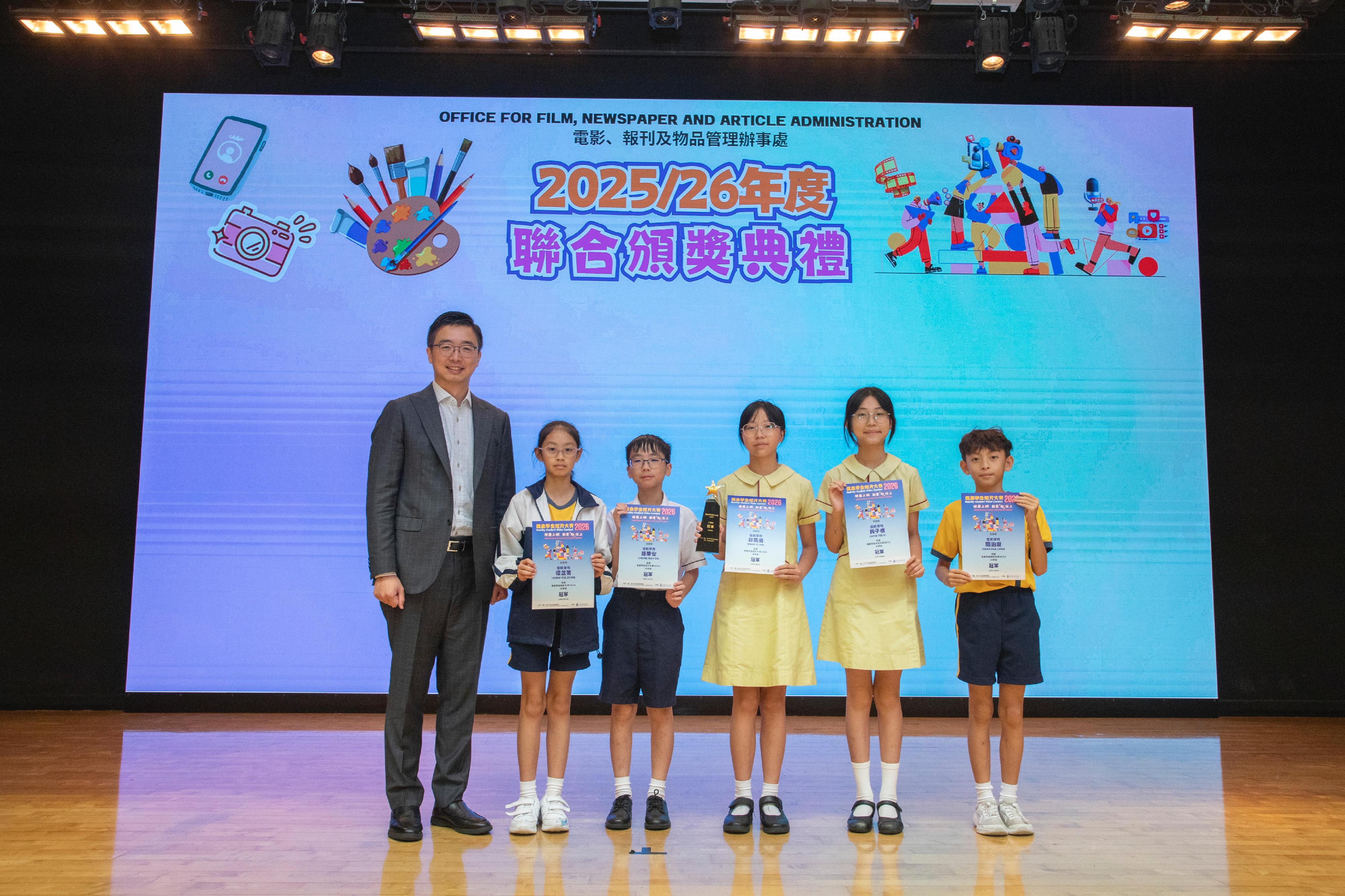電影、報刊及物品管理辦事處今日(七月四日)就「健康學生短片大賽2026」、「《淫褻及不雅物品管制條例》口號創作及填色比賽2025-26」及「健康貼圖設計大賽」舉行頒獎典禮。圖示「健康學生短片大賽2026」得獎者與嘉賓合照。