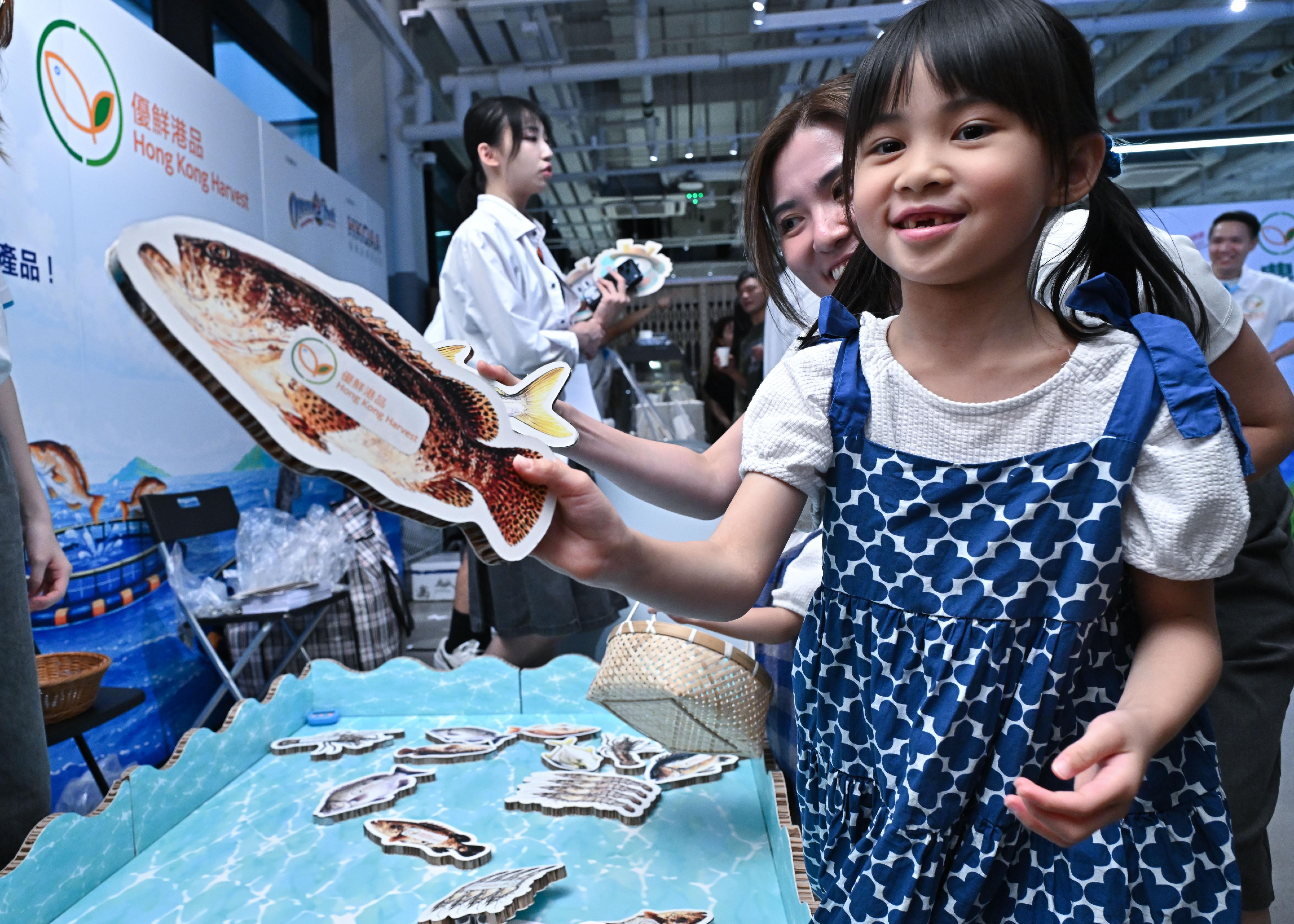 The Agriculture, Fisheries and Conservation Department held the launching ceremony for the new unified brand for local agricultural and fisheries products, Hong Kong Harvest, today (July 4) at Central Market. Starting today, the public can purchase a variety of products bearing the Hong Kong Harvest certification logo. Photo shows the public participating in games at a booth.