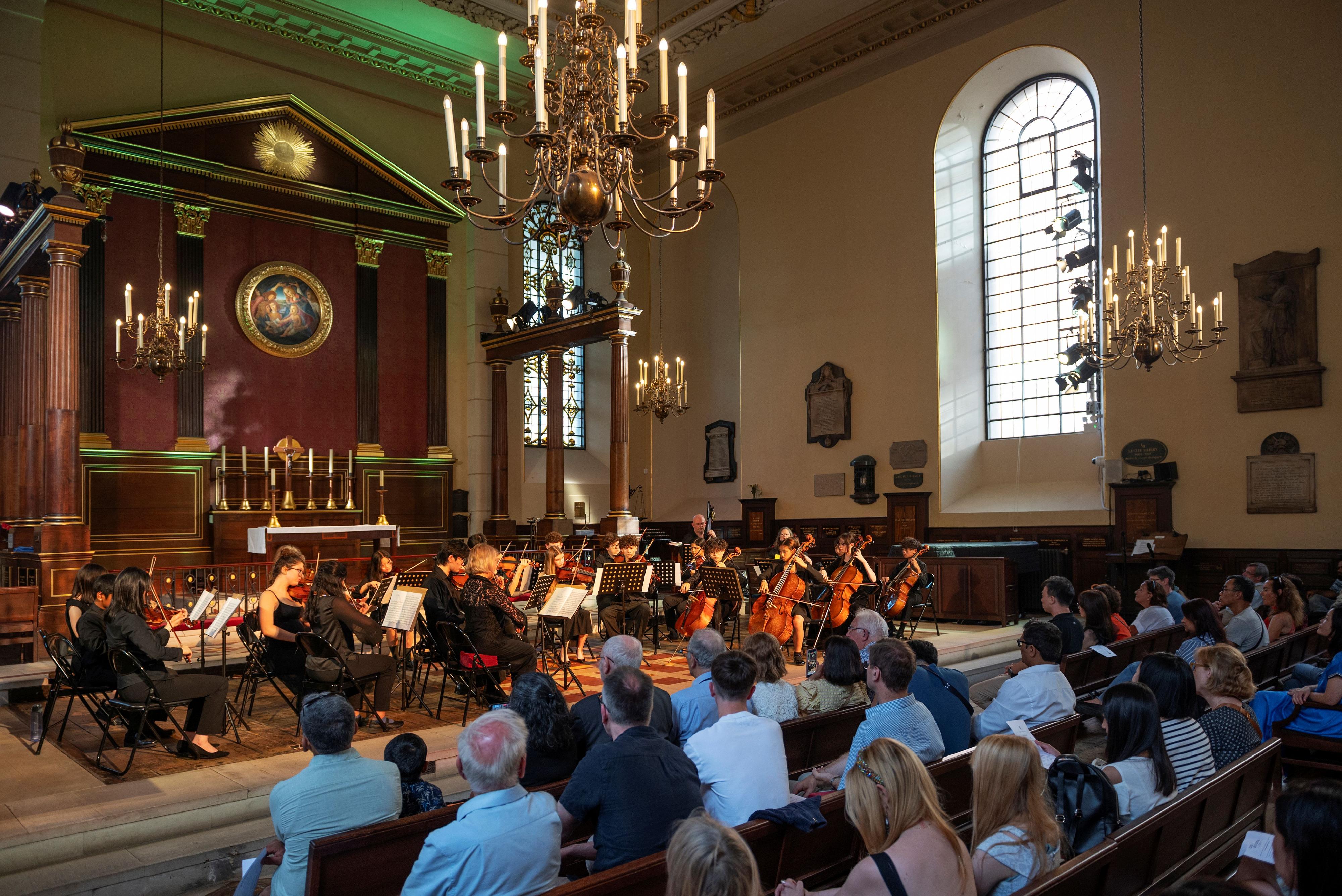 The Hong Kong Economic and Trade Office in London supported the Musicus Society's cultural exchange tour in partnership with the English Chamber Orchestra from July 1 to 6 (London time). Photo shows the tour members performing a string ensemble with local students and musicians from the United Kingdom at the historic St. Paul's Church at Covent Garden, London, in the evening of July 5 (London time).