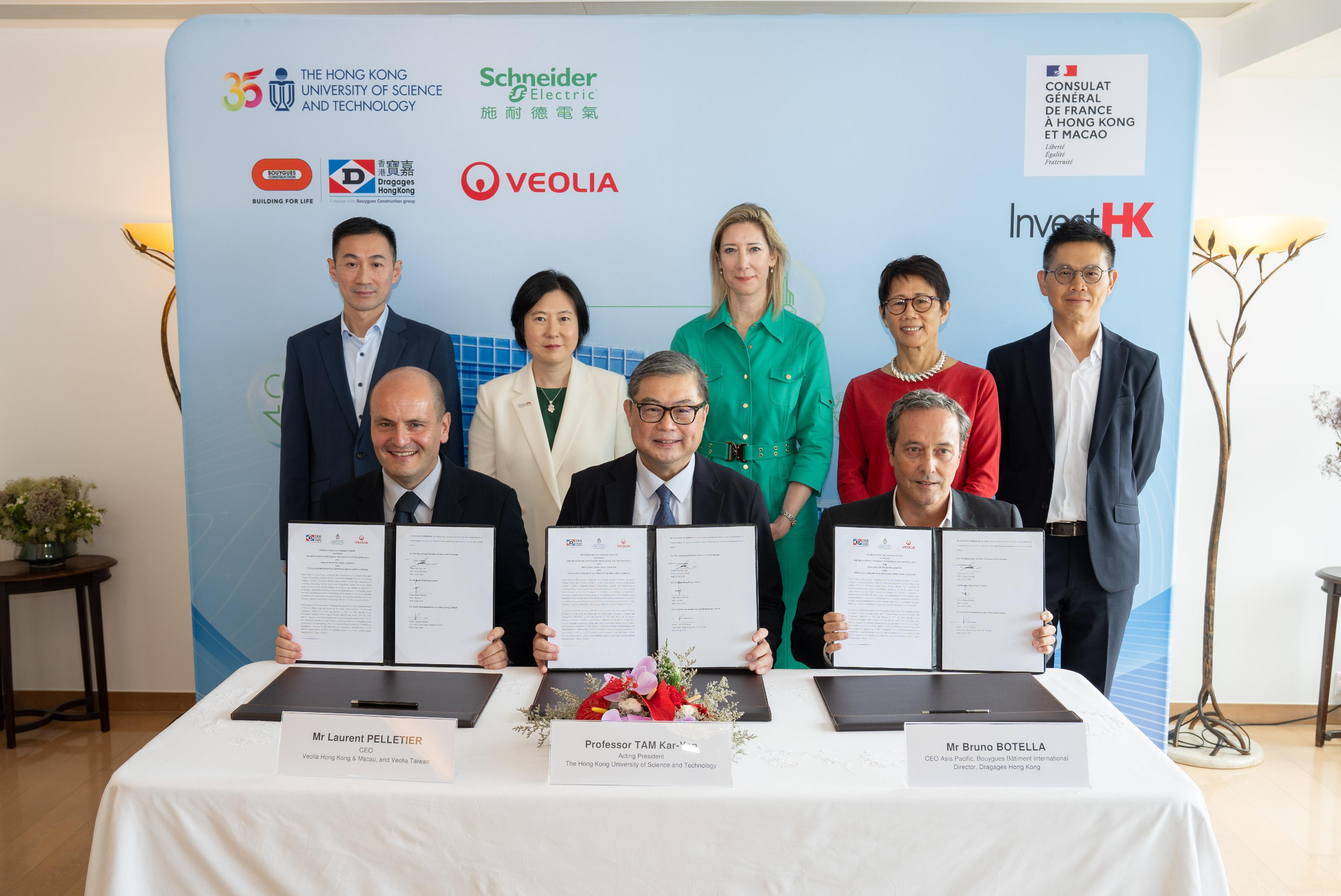 Invest Hong Kong (InvestHK) today (July 8) welcomed the signing of the first works contract and a second-phase Memorandum of Understanding between the Hong Kong University of Science and Technology (HKUST) and a consortium of French companies, marking a progressive step that translates the low-carbon retrofit partnership commenced in September 2025 into concrete action. Photo shows the first works contract signed by the Acting President of HKUST, Professor Tam Kar-yan (front row, centre); the Chief Executive Officer Asia Pacific of Bouygues-Dragages, Mr Bruno Botella (front row, right); and the Chief Executive Officer of Veolia Hong Kong and Macau, Mr Laurent Pelletier (front row, left). The signing ceremony was witnessed by the Consul-General of France in Hong Kong and Macau, Ms Christile Drulhe (back row, centre); the Director-General of Investment Promotion of InvestHK, Ms Alpha Lau (back row, second left); the President of Schneider Electric Hong Kong, Mr Jonathan Chiu (back row, first right); the Commissioner for Climate Change of the Environment and Ecology Bureau, Mr Sammy Yeung (back row, first left); and the Chief Development Strategist of the Institute for the Environment at HKUST, Professor Christine Loh (back row, second right).