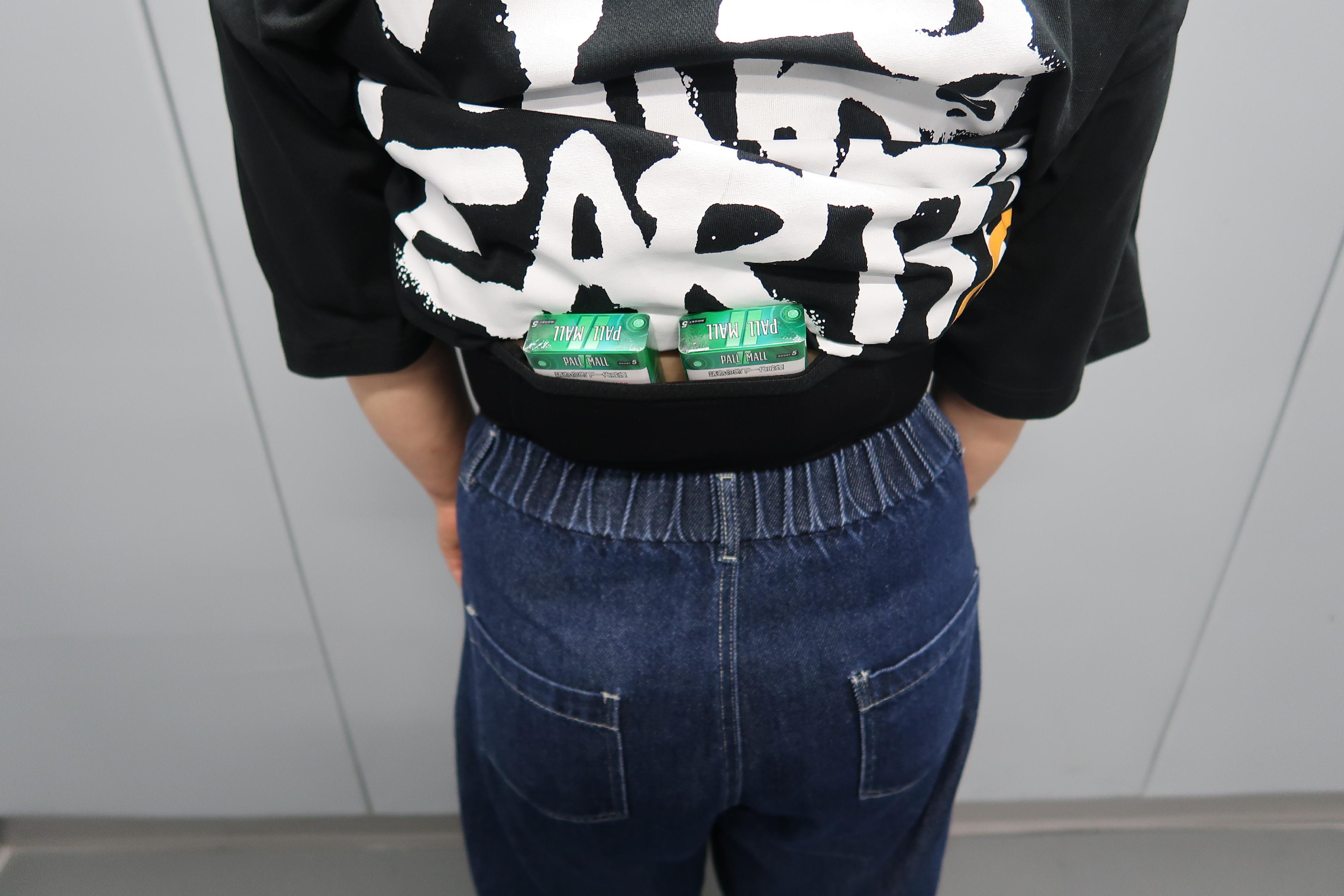 An incoming female passenger was sentenced to four weeks' imprisonment with a fine of $1,000 by the Fanling Magistrates' Courts today (July 9) for possessing duty-not-paid cigarettes and failing to declare them to Customs officers, in contravention of the Dutiable Commodities Ordinance. Photo shows duty-not-paid cigarettes concealed around the waist of a 54-year-old incoming local female passenger that were covered by a T-shirt.