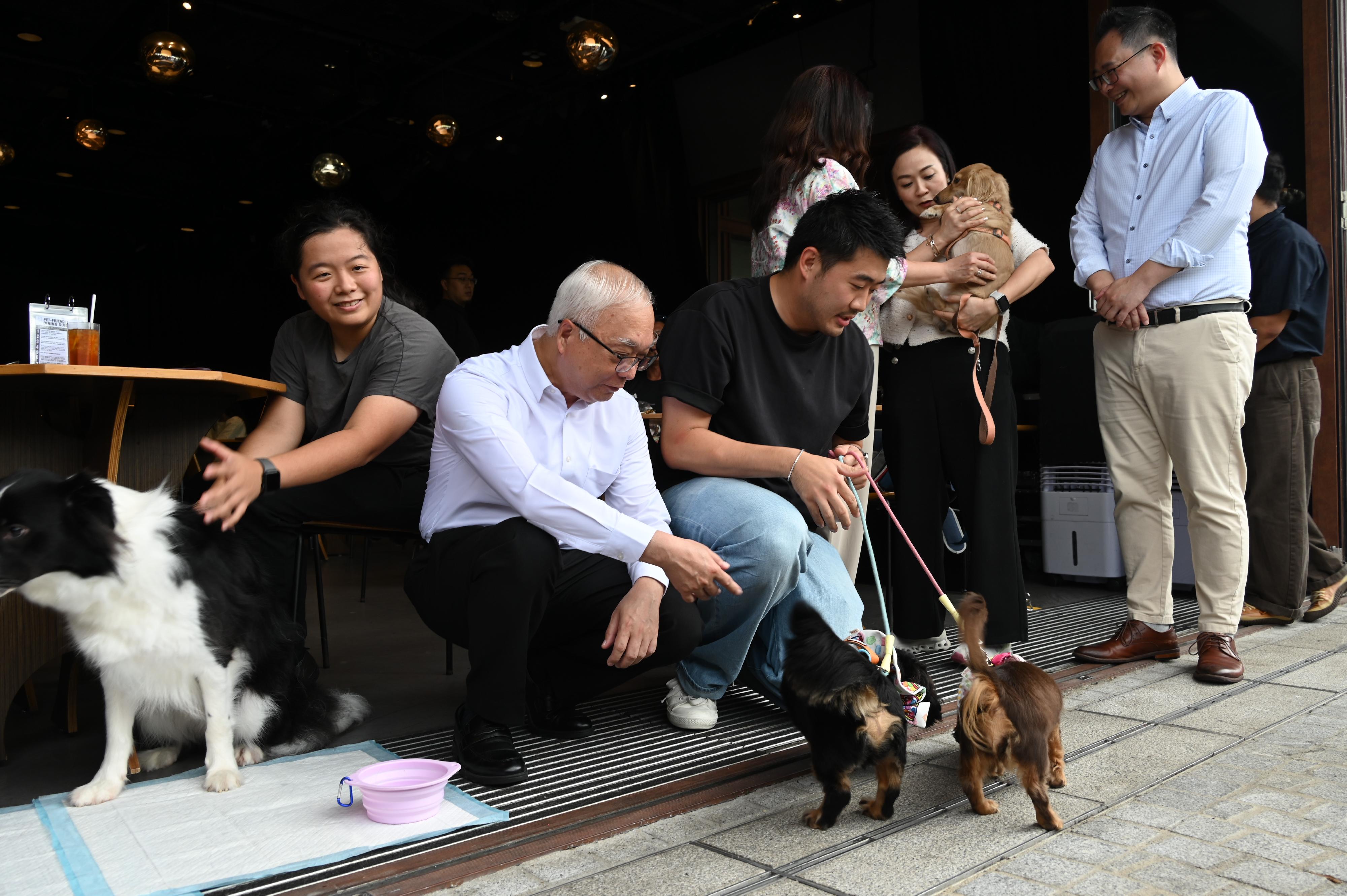 Customers are allowed to bring dogs into the first batch of more than 940 permitted food premises starting today (July 9). Photo shows the Secretary for Environment and Ecology, Mr Tse Chin-wan (second left), and the Chairman and the Deputy Chairman of the Panel on Food Safety and Environmental Hygiene of the Legislative Council, Ms Chan Hoi-yan (second right) and Mr Yang Wing-kit (first right), visiting a permitted food premises in West Kowloon Cultural District this afternoon and exchanging views with customers bringing dogs.