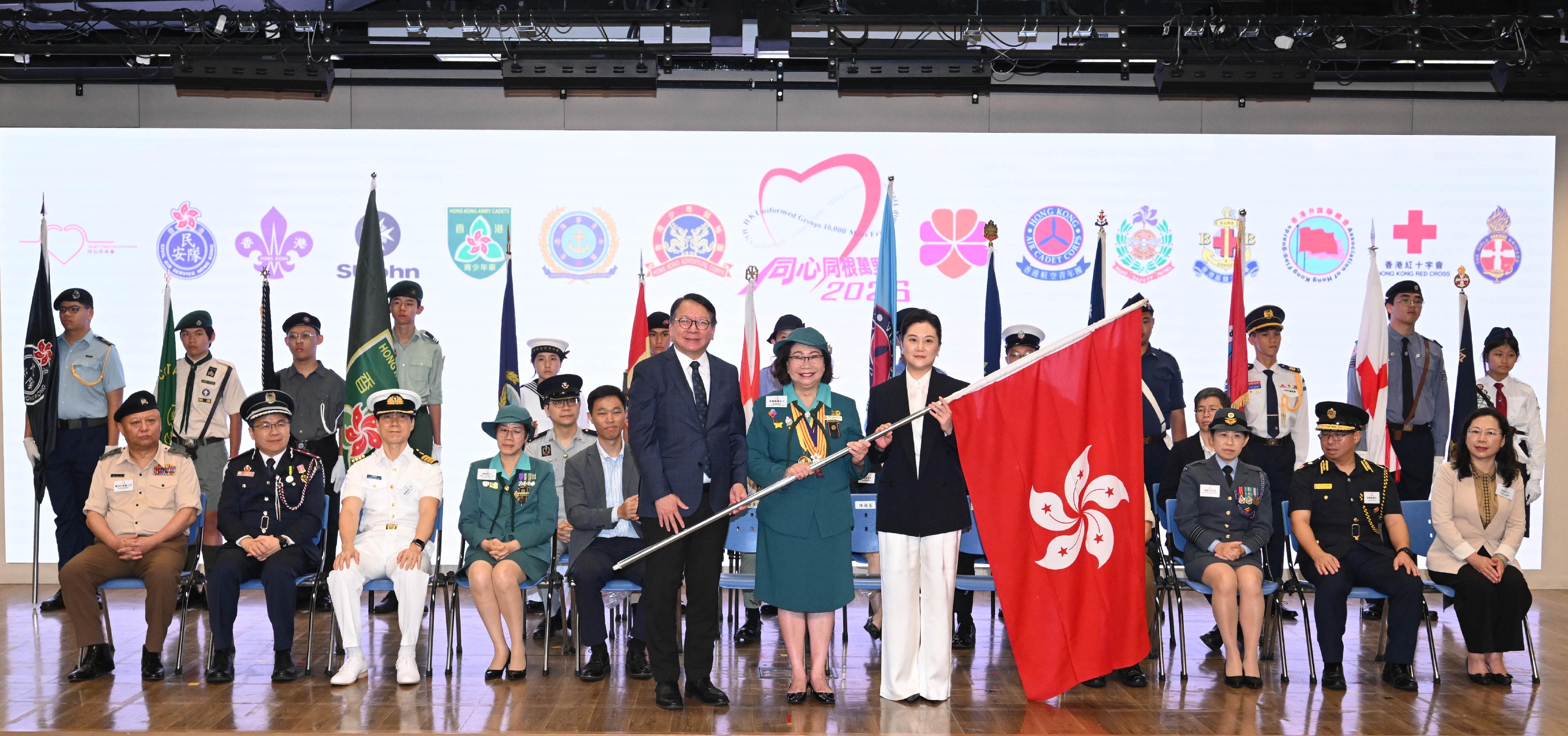 政務司司長陳國基(左)今日(七月十一日)在同心同根萬里行2026授旗禮上,頒授區旗予同心同根會創會會長、同心同根萬里行2026活動召集人暨團長梁唐青儀(中)和同心同根萬里行2026榮譽團長顧笑洋(右)。