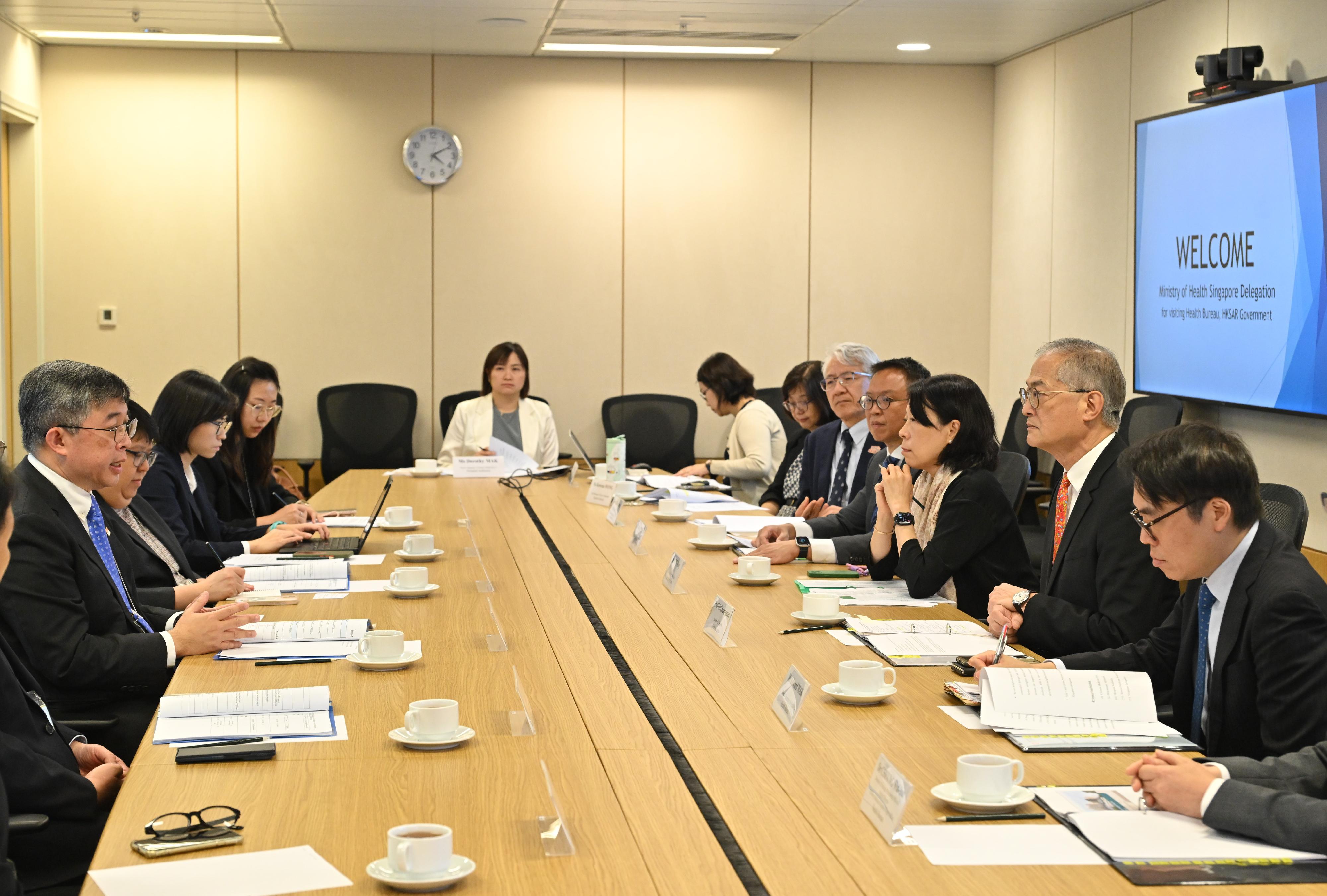 The Secretary for Health, Professor Lo Chung-mau (second right), meets with a delegation led by the Director-General of Health of the Ministry of Health Singapore, Professor Kenneth Mak (first left), today (July 14) for a detailed exchange on the development of Chinese medicine in the two places.