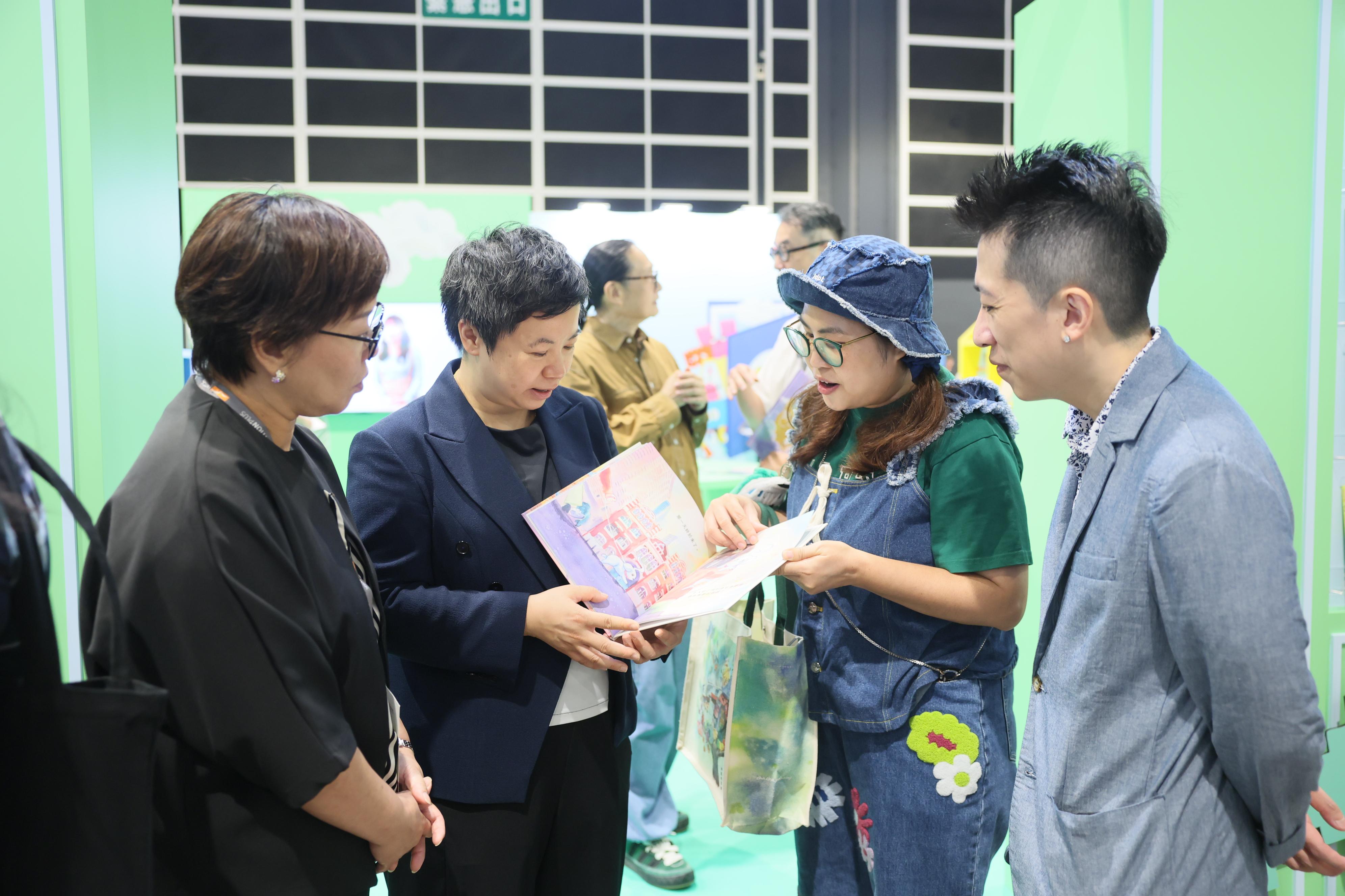 The 36th Hong Kong Book Fair is being held from today (July 15) till July 21 at the Hong Kong Convention and Exhibition Centre, the Cultural and Creative Industries Development Agency under the Culture, Sports and Tourism Bureau sponsored the trade to organise an array of events at the Fair. Photo shows the Commissioner for Cultural and Creative Industries, Miss Drew Lai (second left), and the Assistant Commissioner for Cultural and Creative Industries, Miss Yvonne Ip (first left), interacting with a local picture book illustrator at the booth of the 3rd Go! Illustrators &ndash; Hong Kong Picture Book Illustrators at International Book Fairs Promotion Scheme.