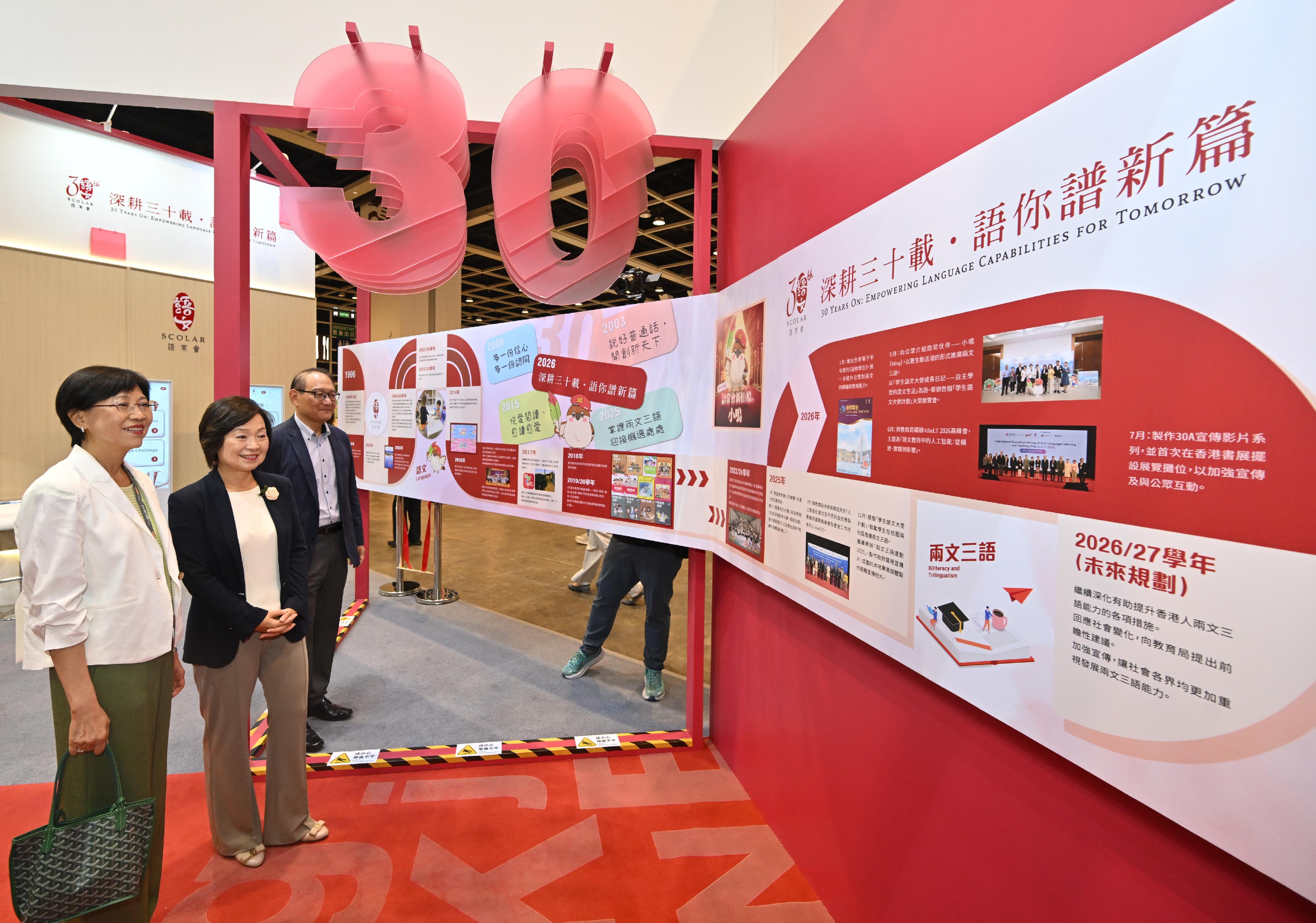 語文教育及研究常務委員會（語常會）以「語常會30周年」為主題，七月十五日至二十一日在第36屆香港書展設置攤位。圖示教育局局長蔡若蓮博士（中）今日（七月十六日）在語常會主席陳黃麗娟博士（左）陪同下參觀語常會的攤位。