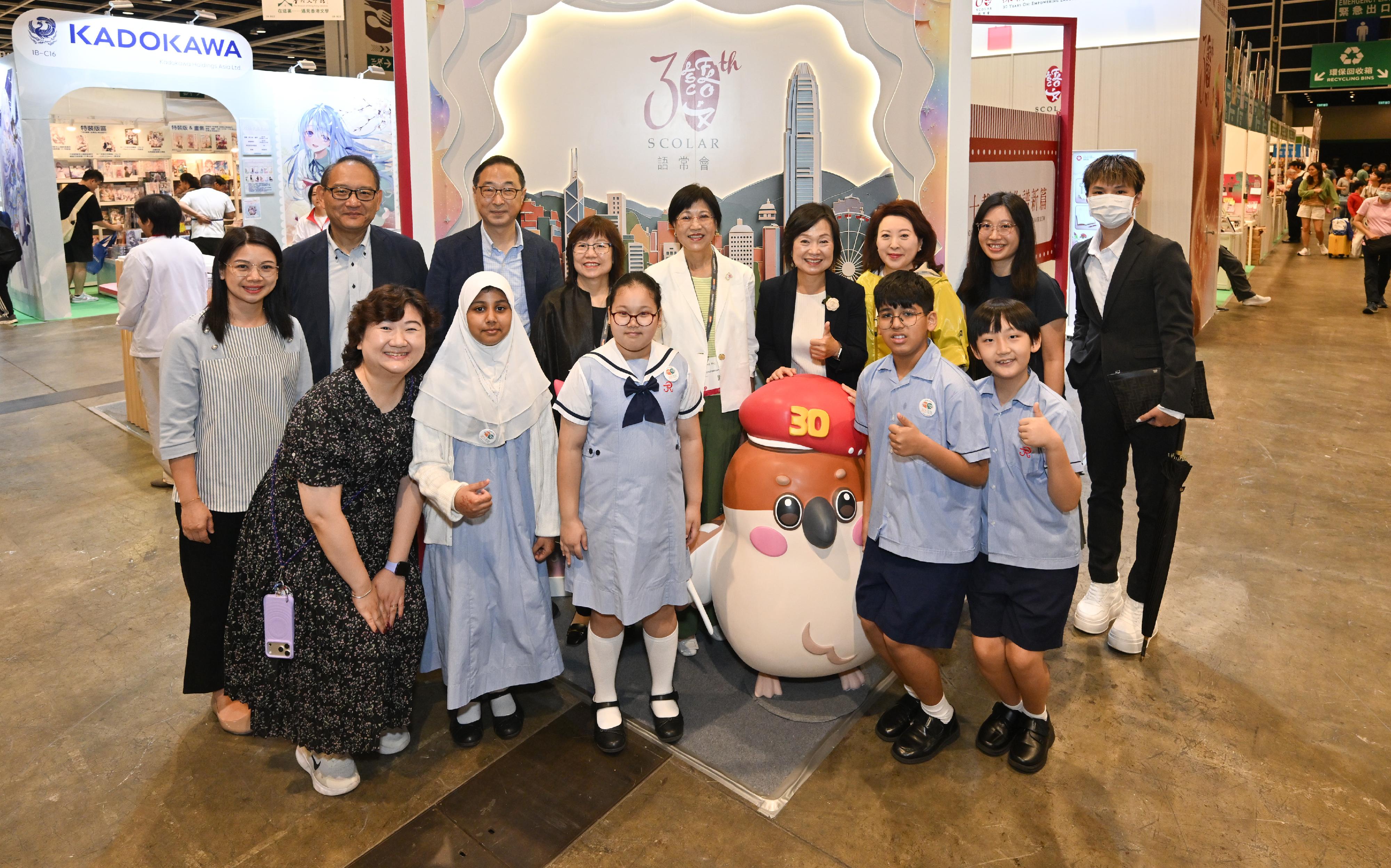 The Standing Committee on Language Education and Research (SCOLAR) has set up a booth themed "30th Anniversary of SCOLAR" at the 36th Hong Kong Book Fair held from July 15 to 21. Photo shows the Secretary for Education, Dr Choi Yuk-lin (second row, fourth right), and the Chairperson of SCOLAR, Dr Anissa Chan (second row, fifth right), posing with members of SCOLAR and Student Language Ambassadors at a themed photo-taking spot.